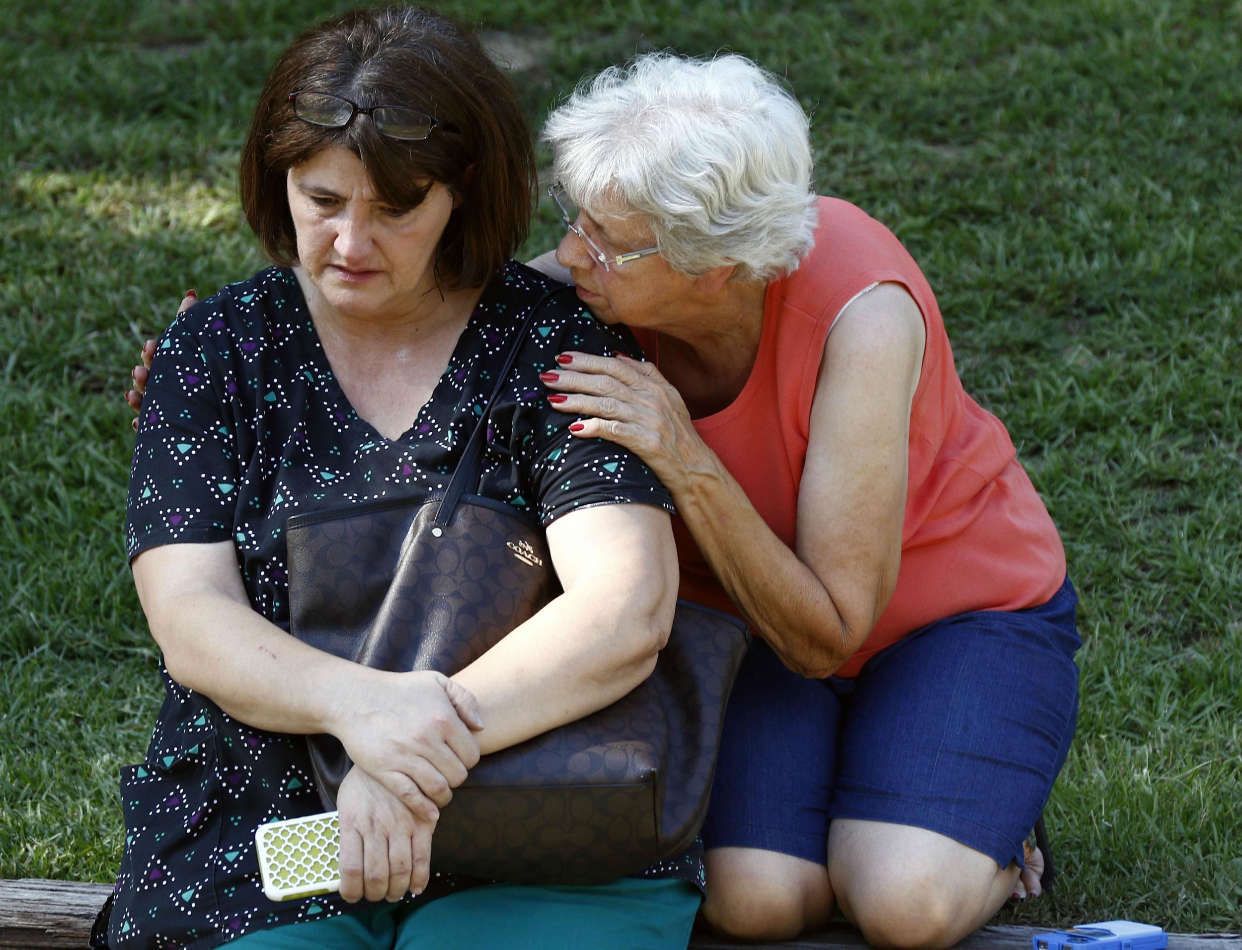 Lisa Dew, the manager of the medical clinic, is comforted after the killings