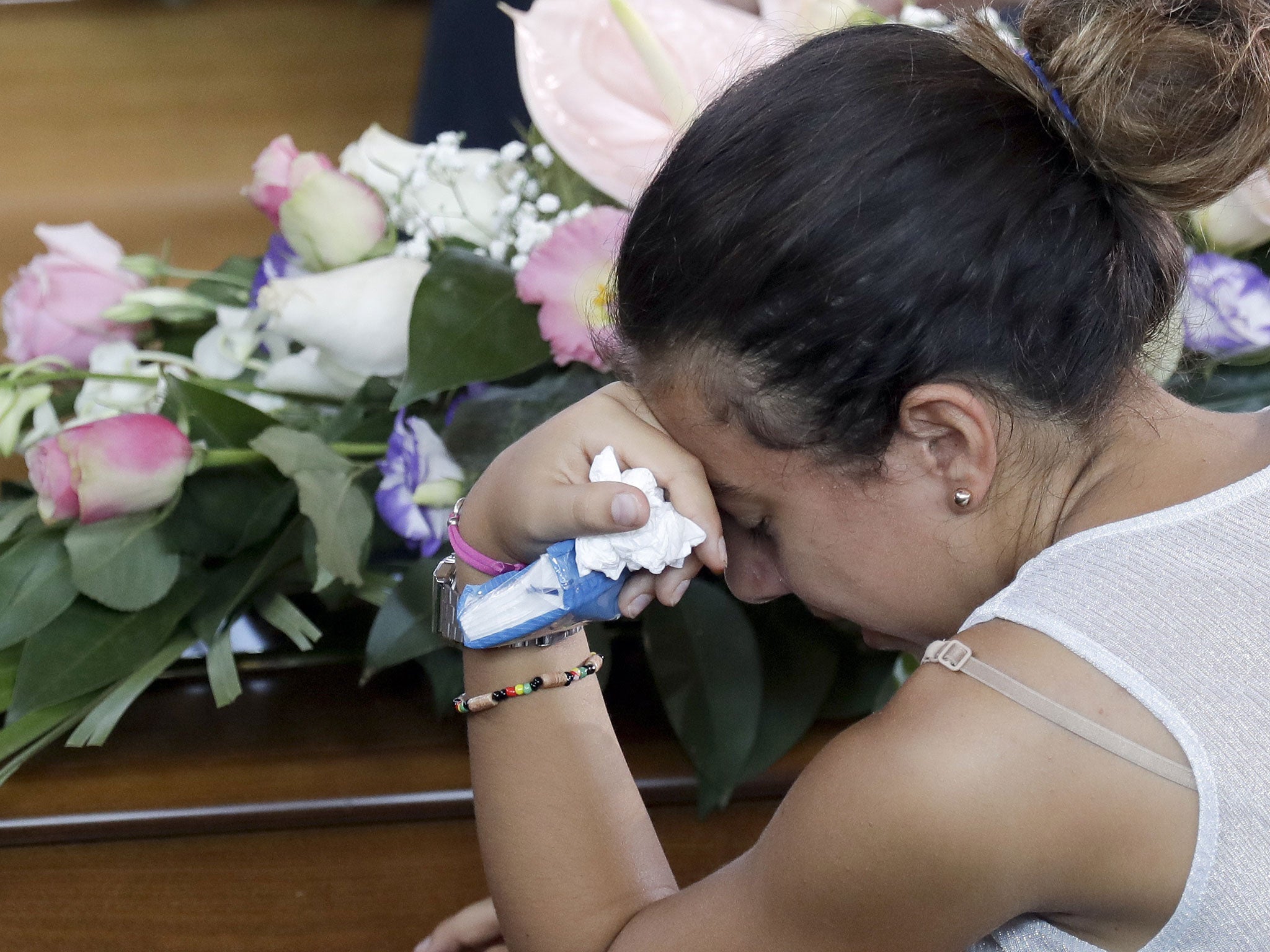 Relatives mourn near coffins of some of the earthquake victims prior to the start of the funeral service in Ascoli Piceno