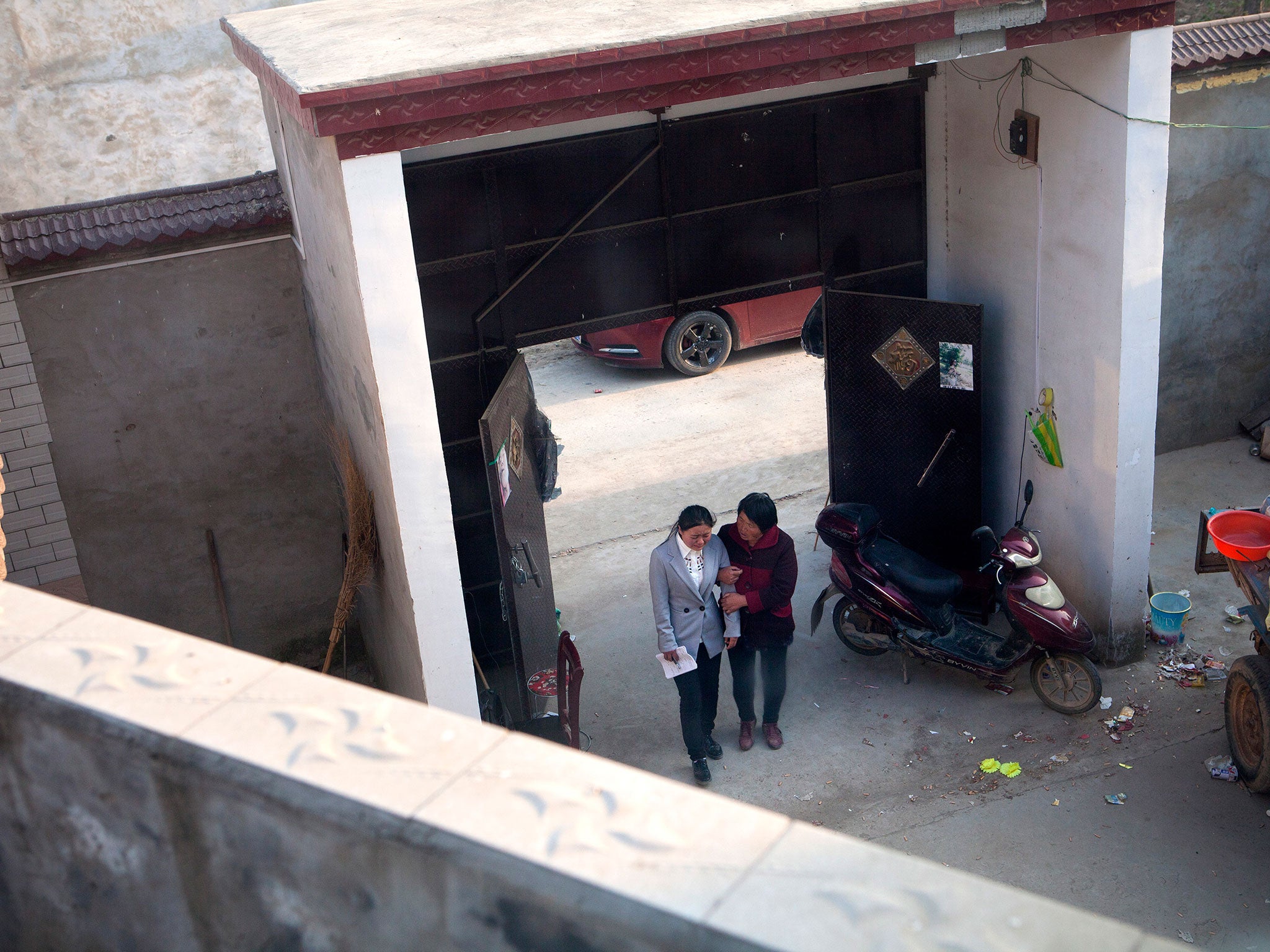 Yan Jinjin, sister of the victim, cries at Li Hongxia’s home in the Zhang village, Henan province, while Duan Sumei, her aunt, supports her