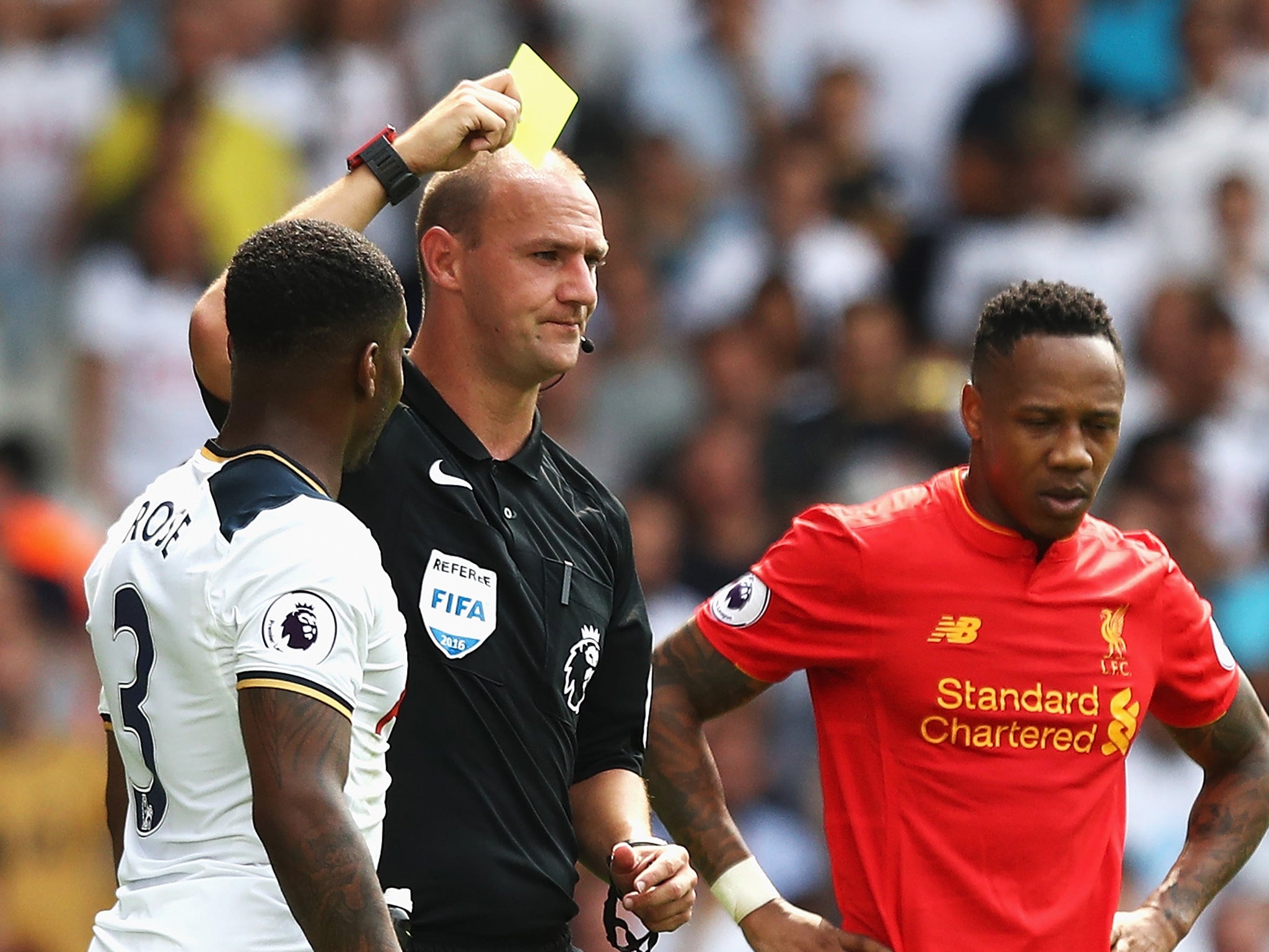 Madley, the match referee, awards Tottenham's Danny Rose a yellow card