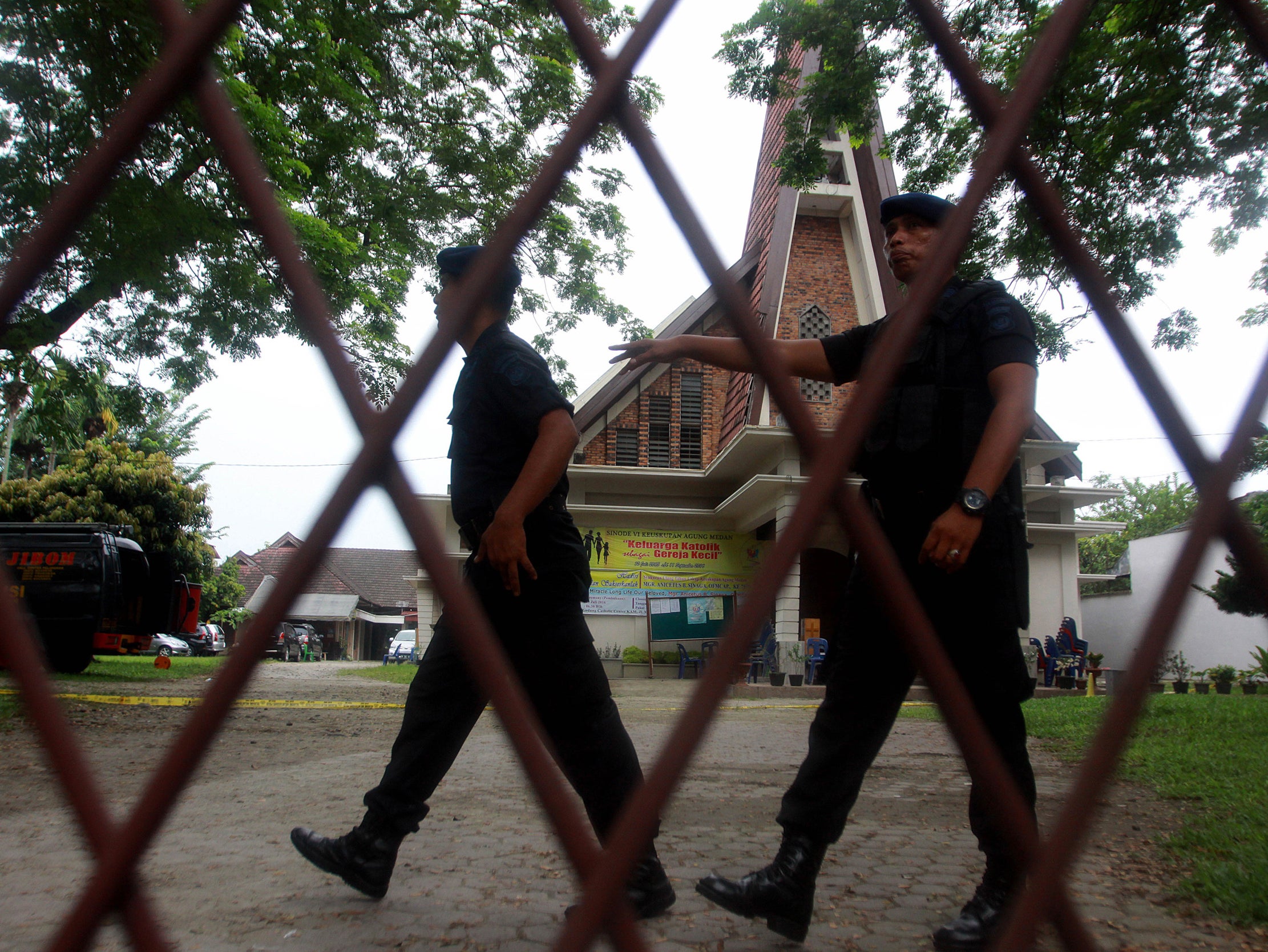 Indonesian policemen examine the Saint Yosef church after a man tried to attack a priest in Medan