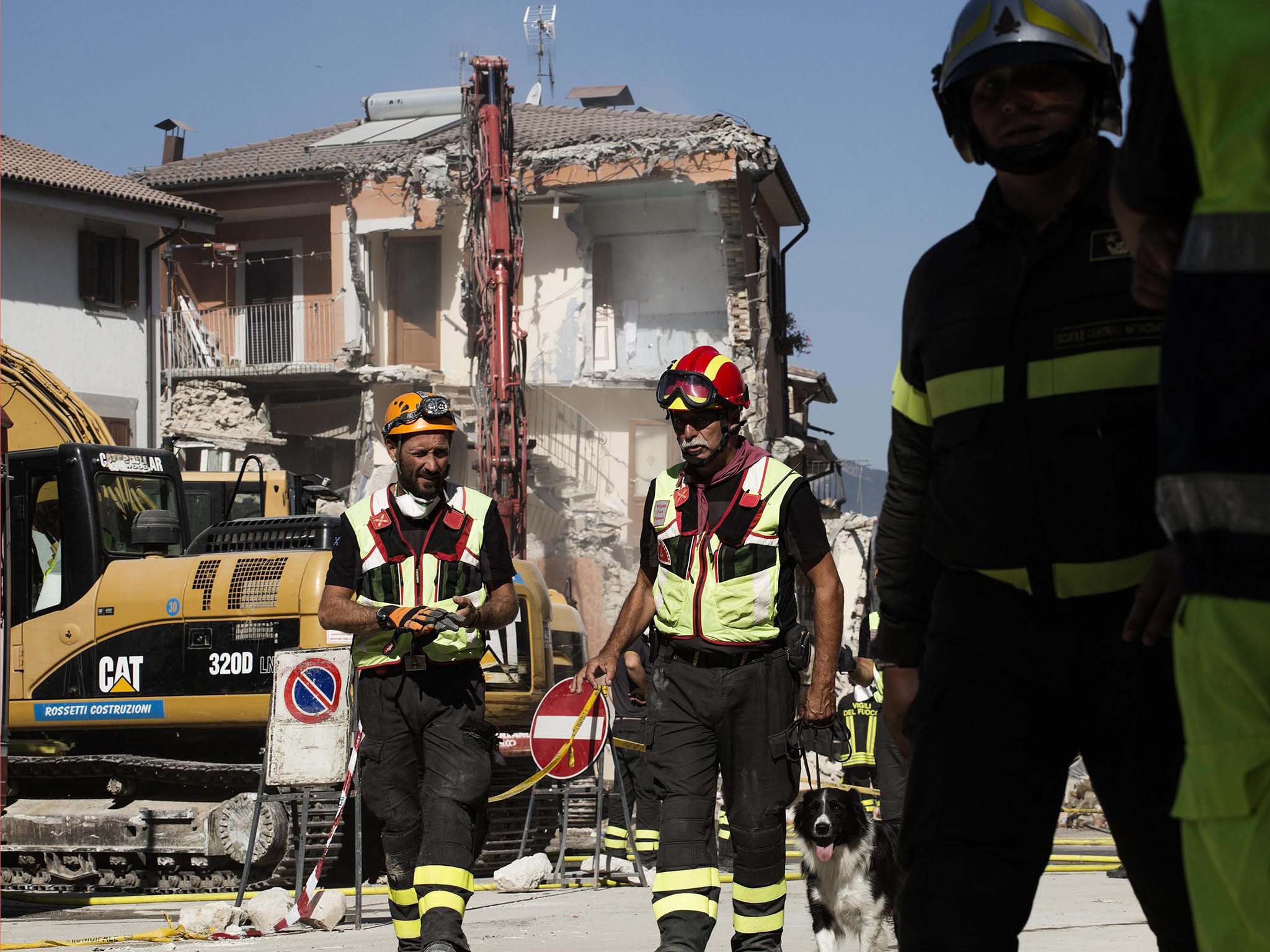 Fire fighters prepare for a controlled demolition in the centre of Amatrice, Italy, yesterday