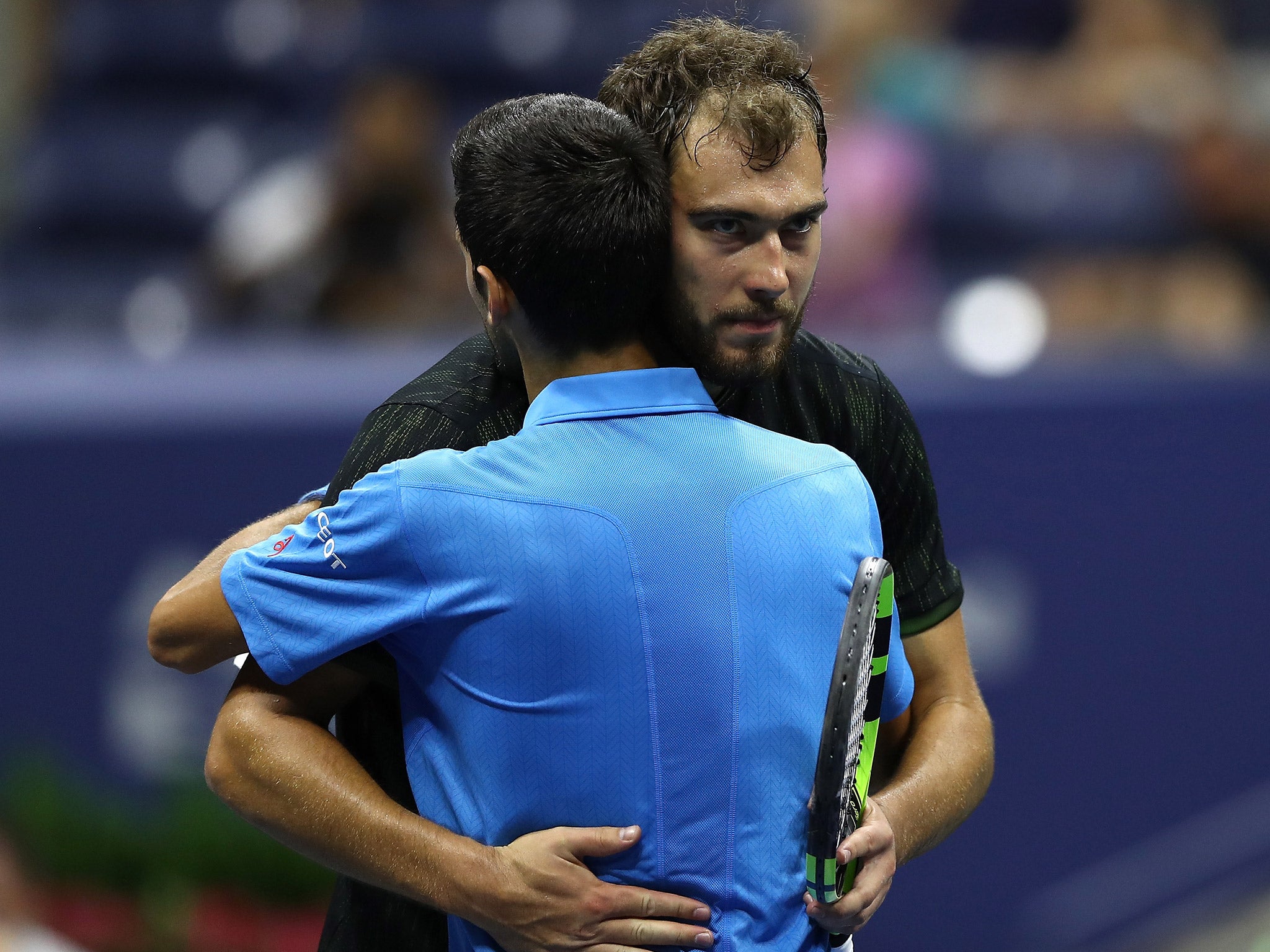 Jerzy Janowicz embraces Novak Djokovic after their first round encounter