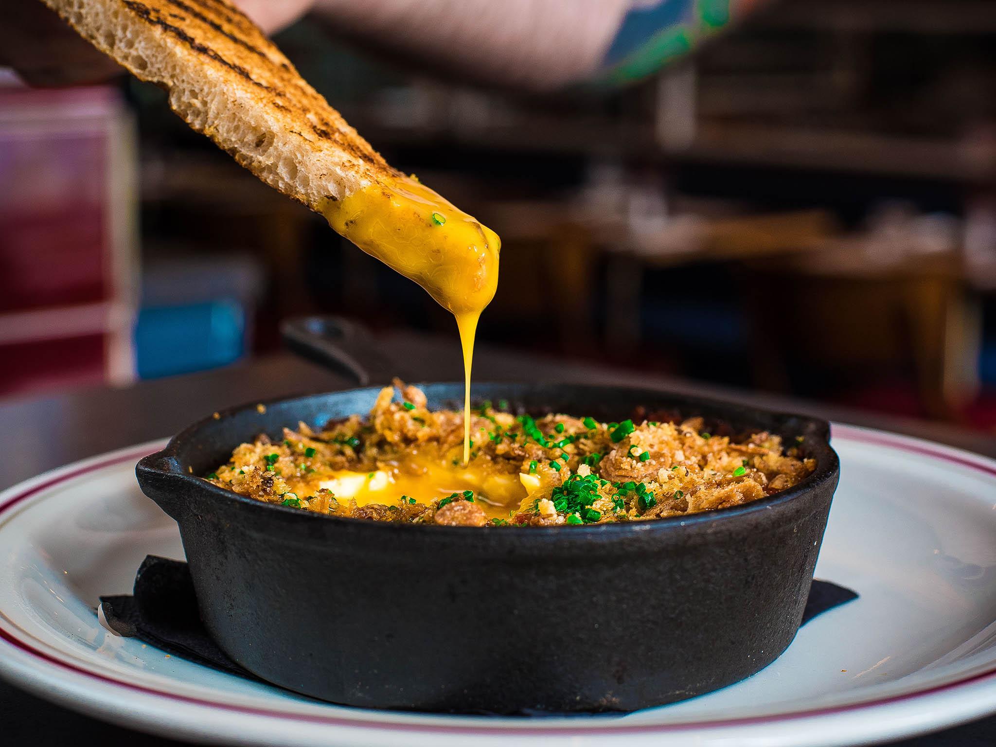 The baked eggs skillet has two free-range eggs baked in rich tomato sauce with avocado, taleggio cheese and parmesan breadcrumb