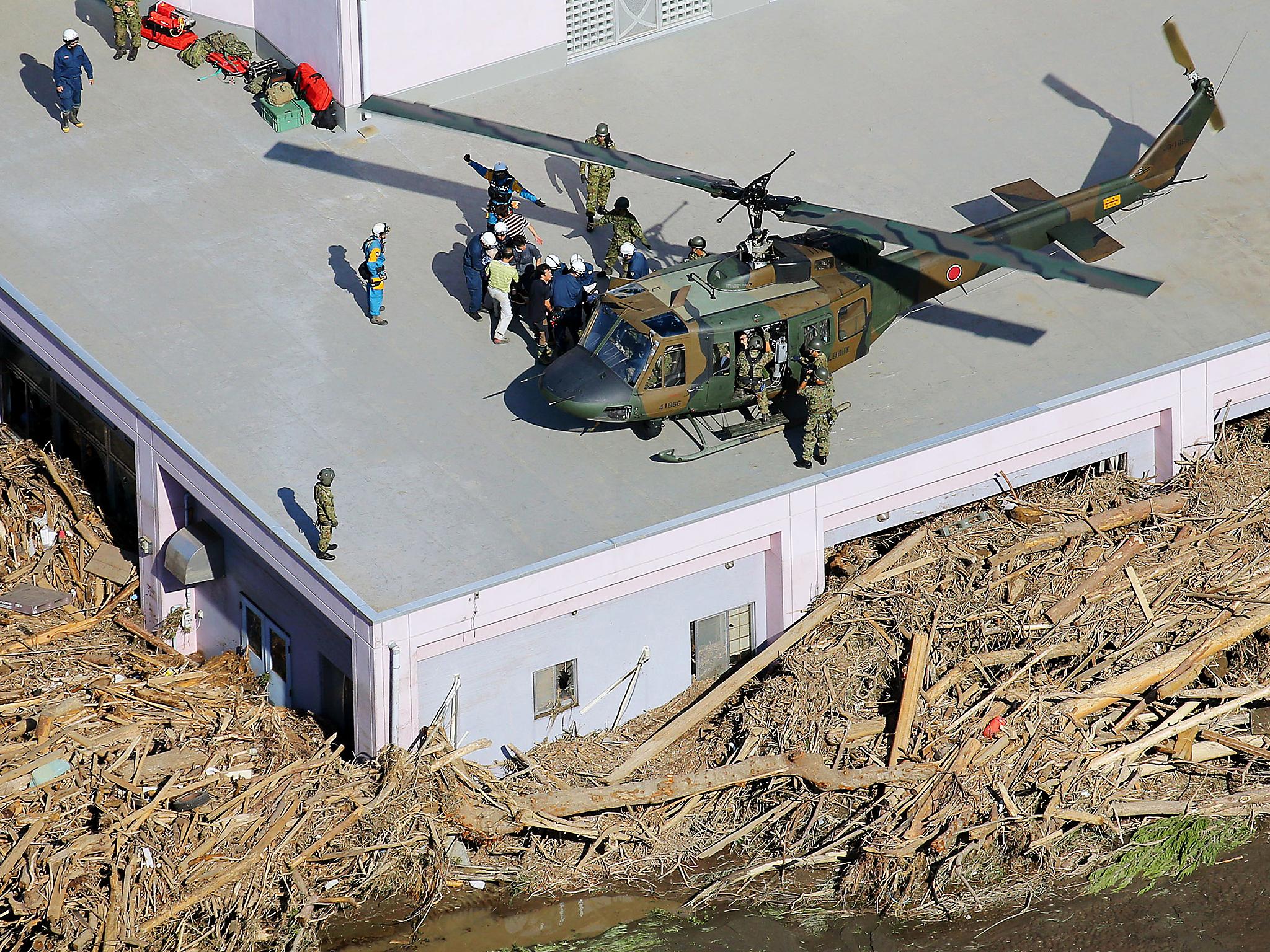 Rescuers evacuate residents from a nursing home damaged by a flooded river in Iwaizumi town, Iwate prefecture