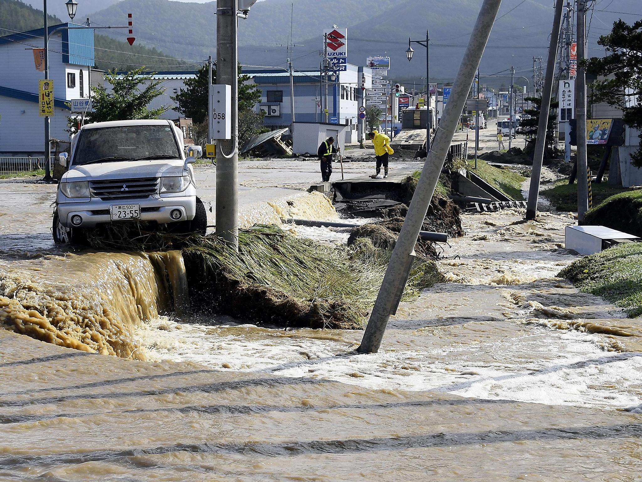 A car is stranded in a flooded road following heavy rain from Typhoon Lionrock in Minamifurano, the northern island of Hokkaido