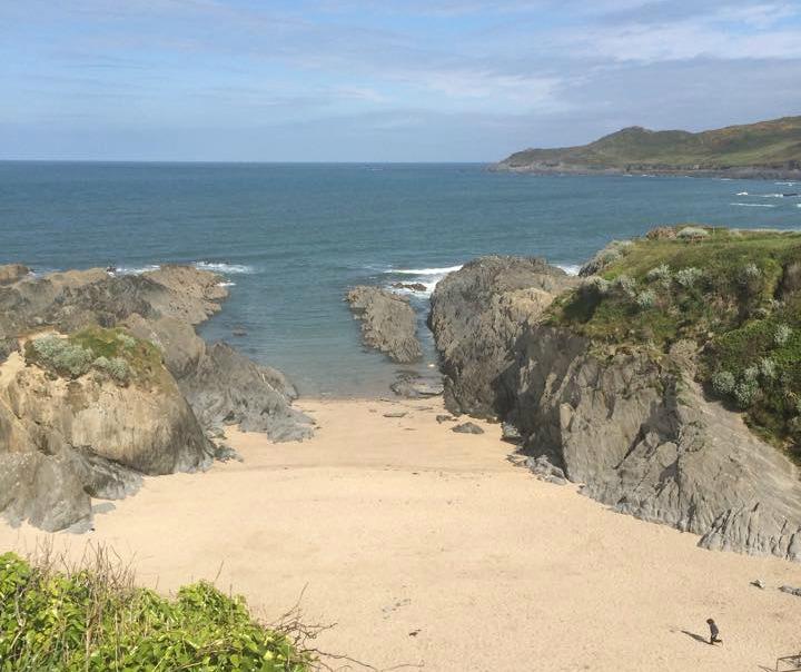 Away from the crowds is a slender slice of golden sand tucked between two rocks