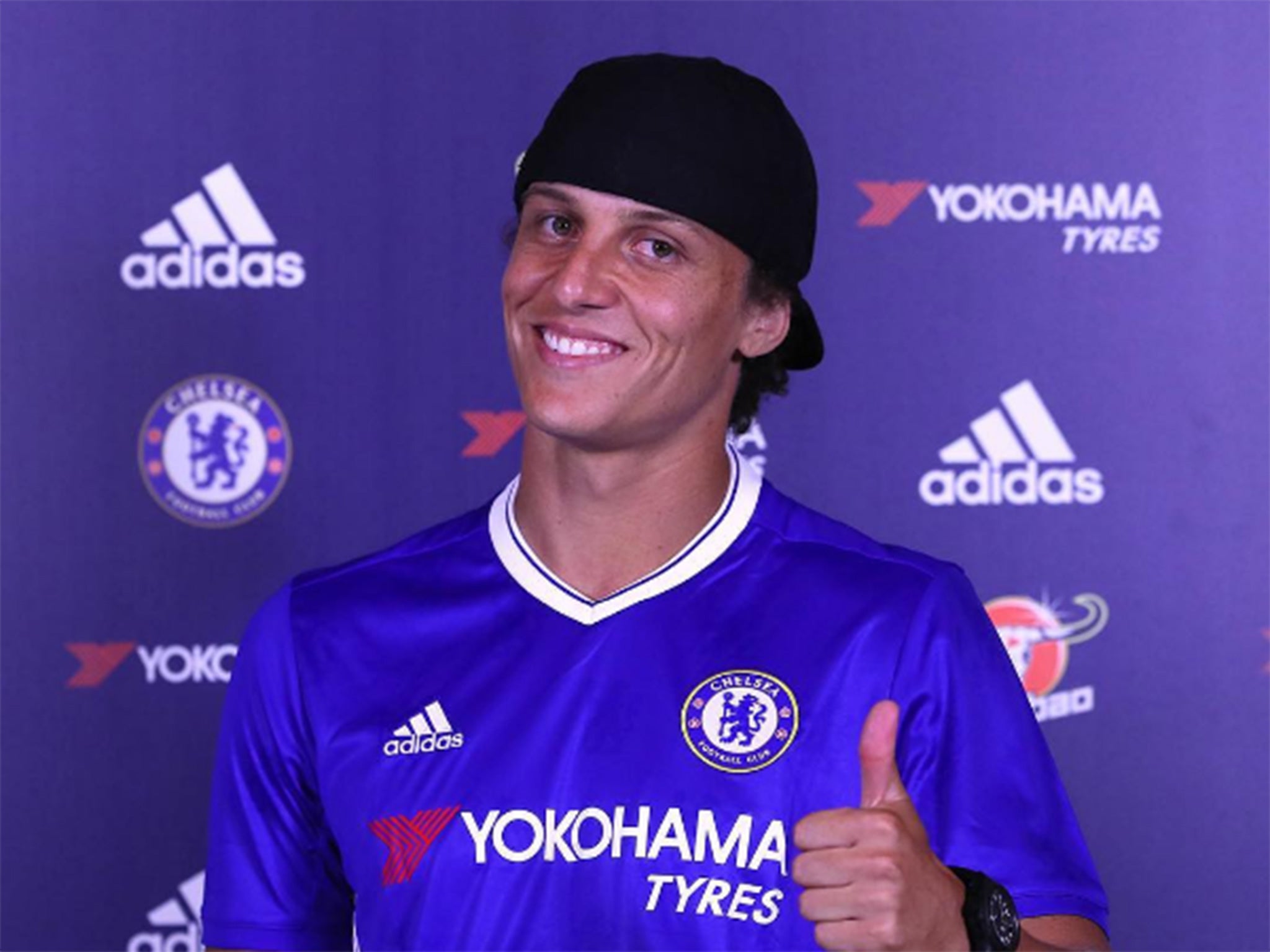 Luiz poses in a Chelsea shirt after signing a three-year contract