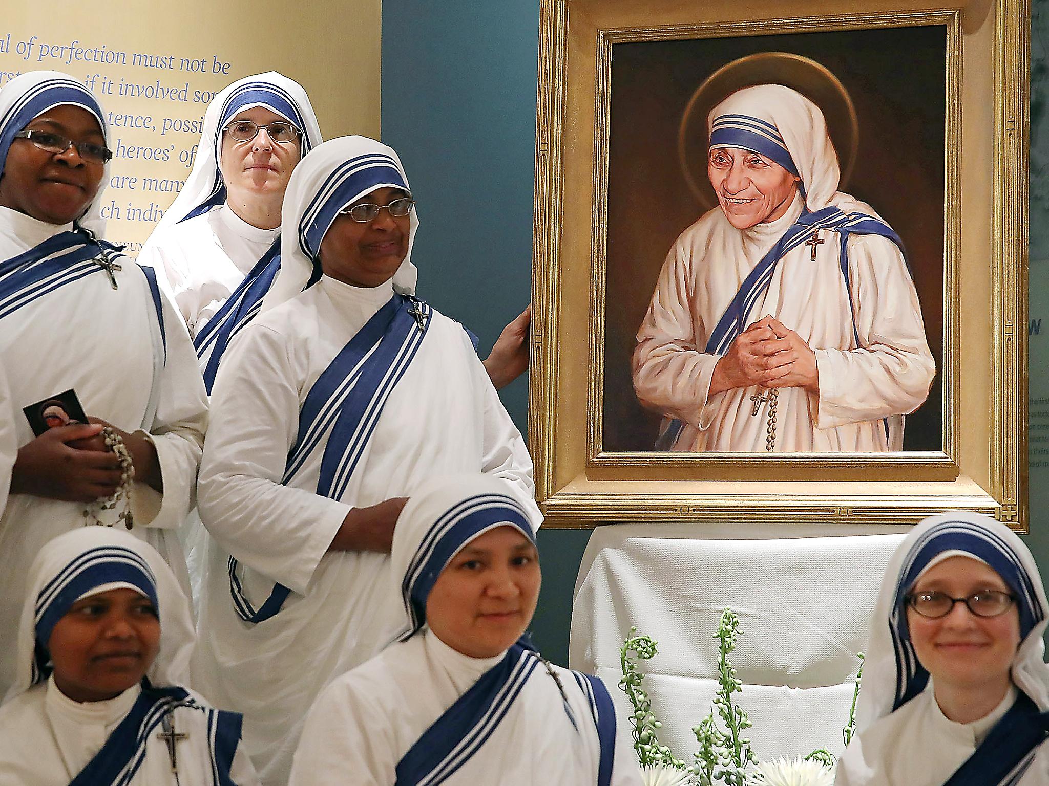 Sisters of the Missionaries of Charity, stand before the canonisation portrait of Mother Teresa at The Saint John Paul II National Shrine, Washington