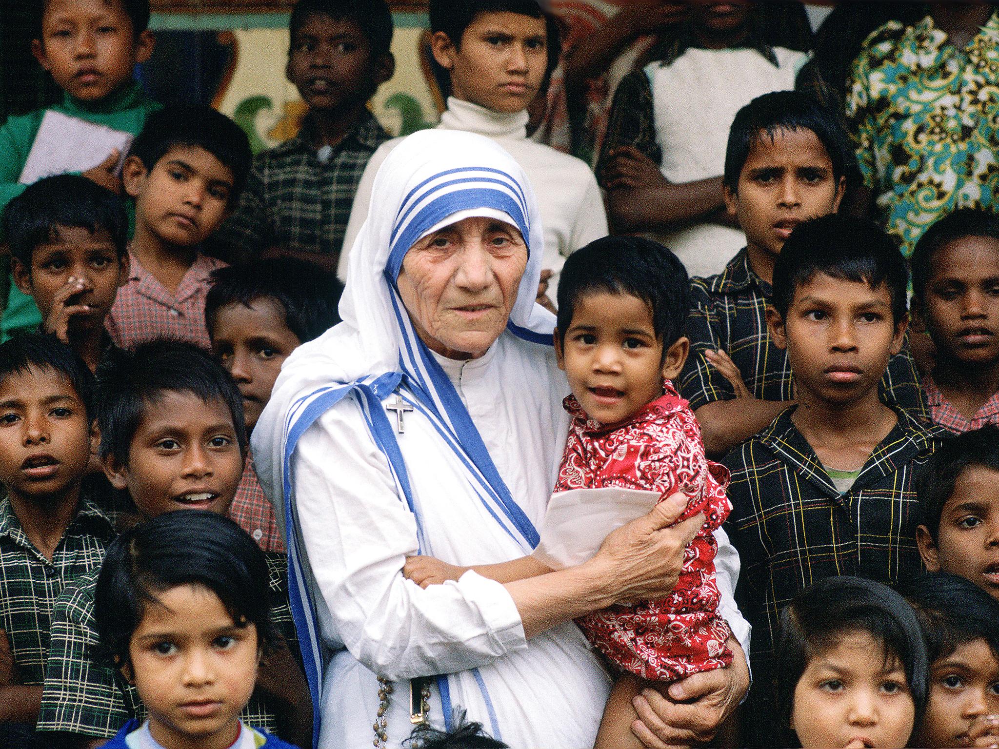 Mother Teresa accompanied by children at her mission in Calcutta