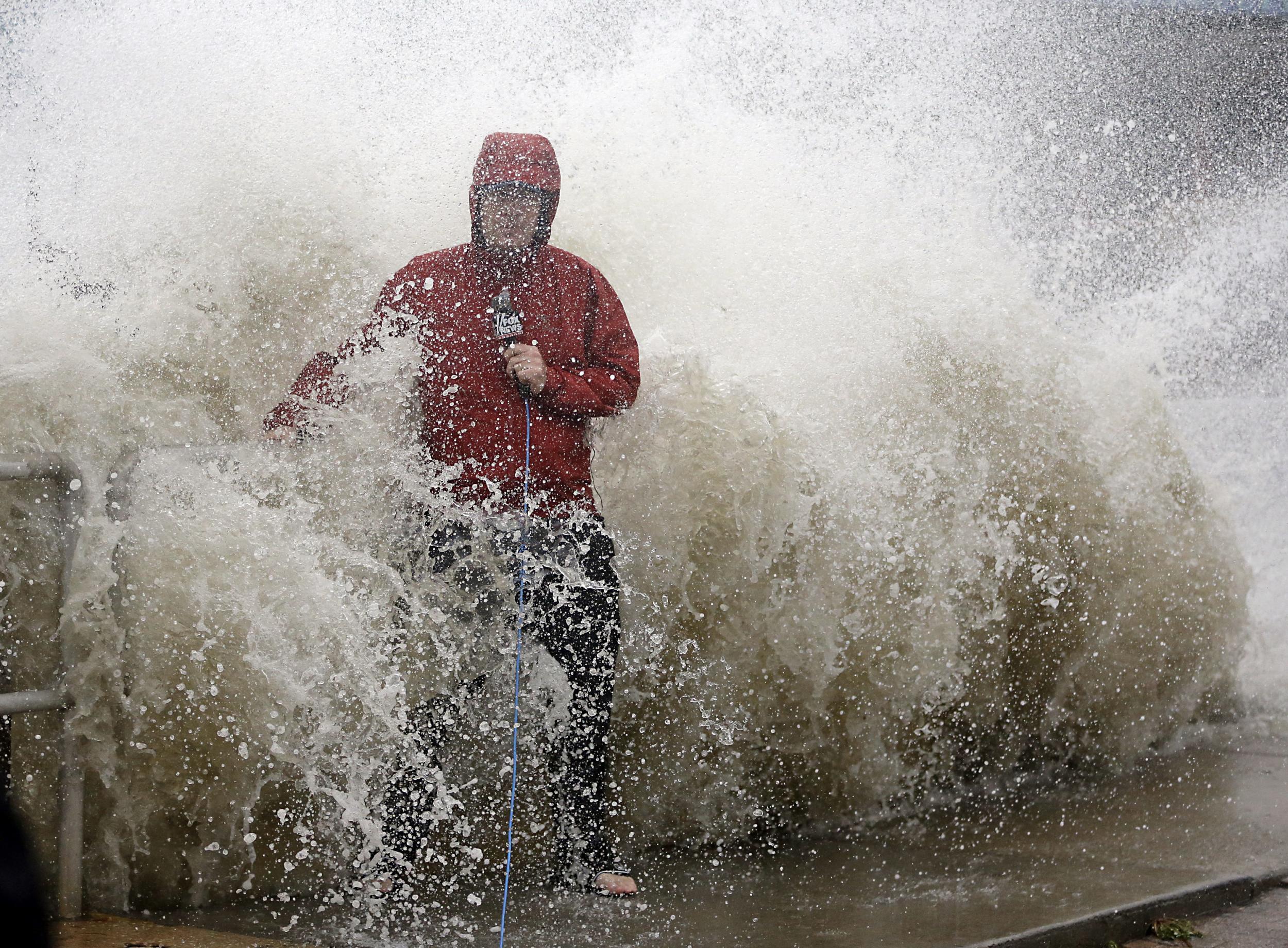 News reporter doing a stand-up report near a sea wall in Cedar Key, Florida