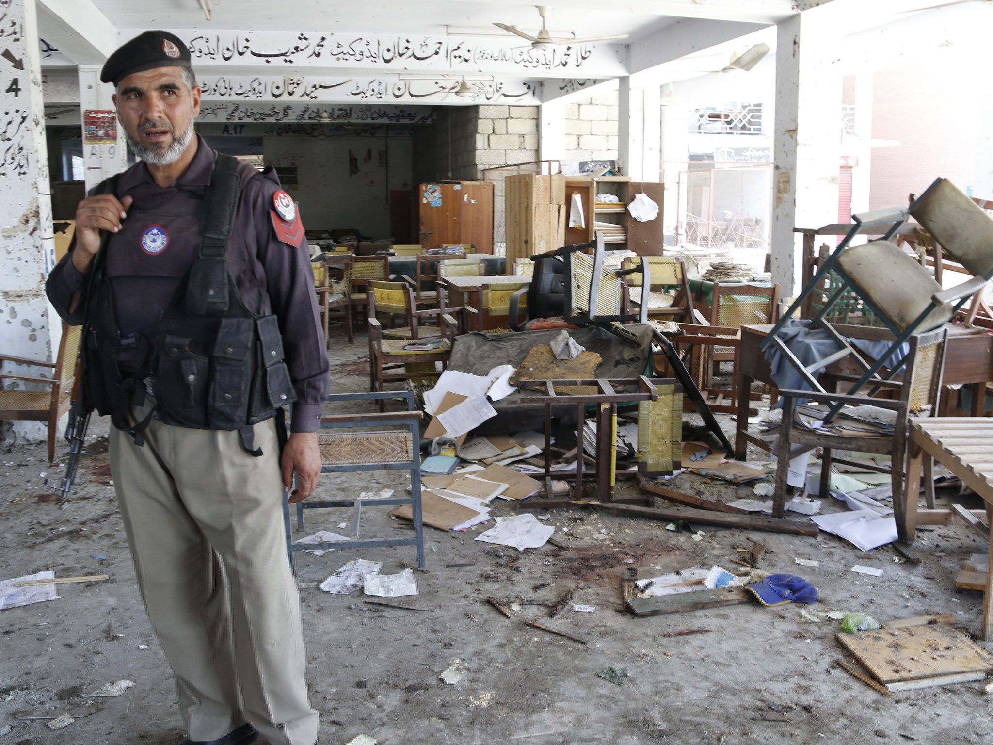 &#13;
A Pakistani security official inspects the site of a suicide bomb explosion that targeted Mardan court &#13;