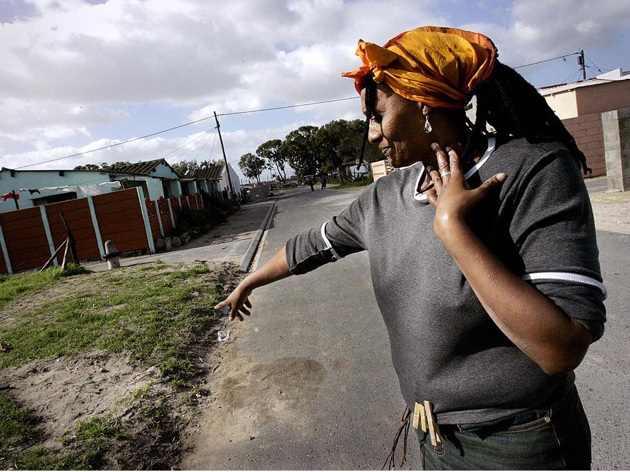 Nyanga resident Pam Mokoena points out the spot where her brother was gunned down outside her house in the Nyanga township, on the outskirts of Cape Town