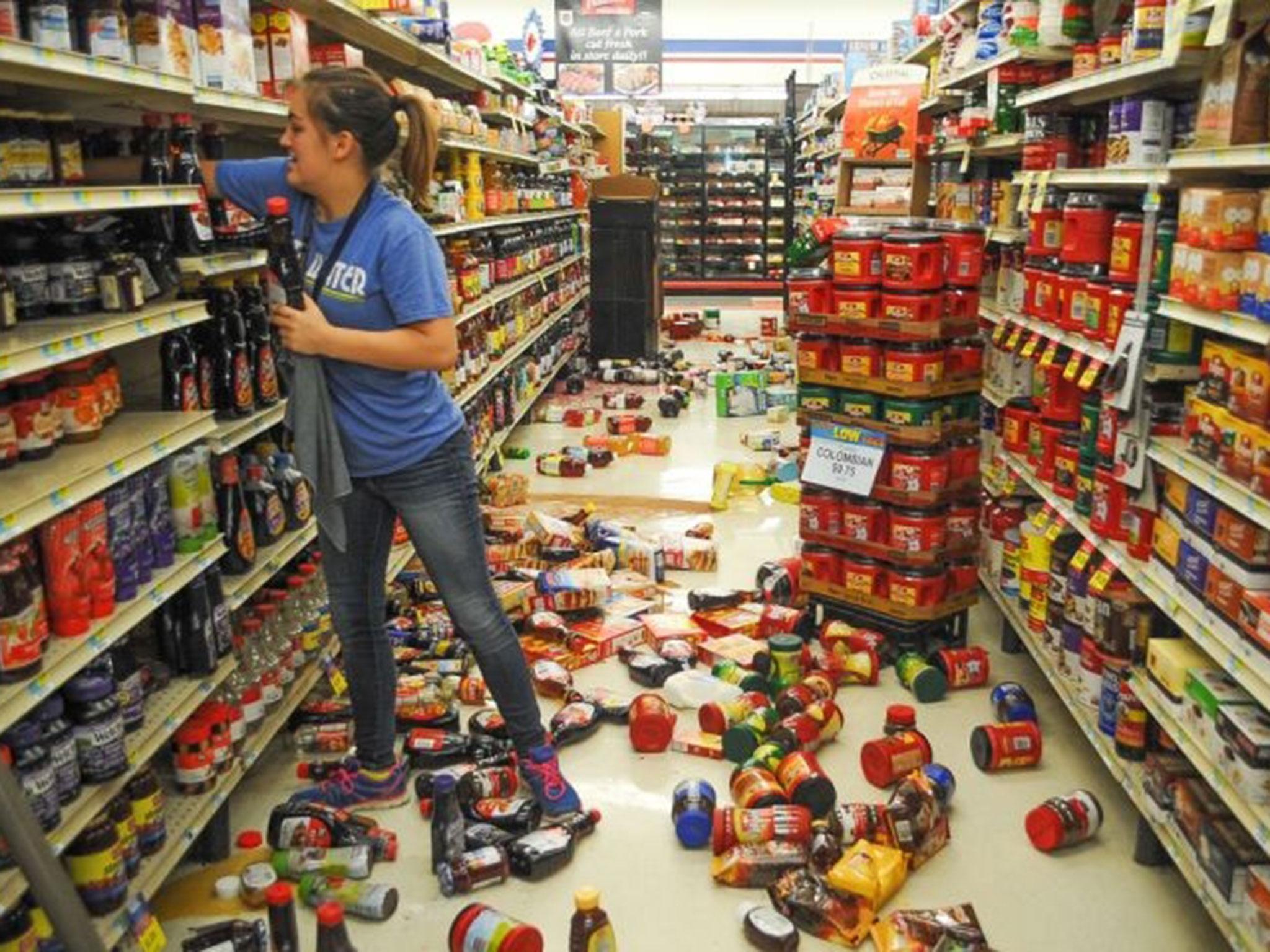 Employee Talia Pershall, 16, restacks bottles of syrup at White's Foodliner grocery store in Pawnee, in north-central Oklahoma, following an earthquake on 3 September