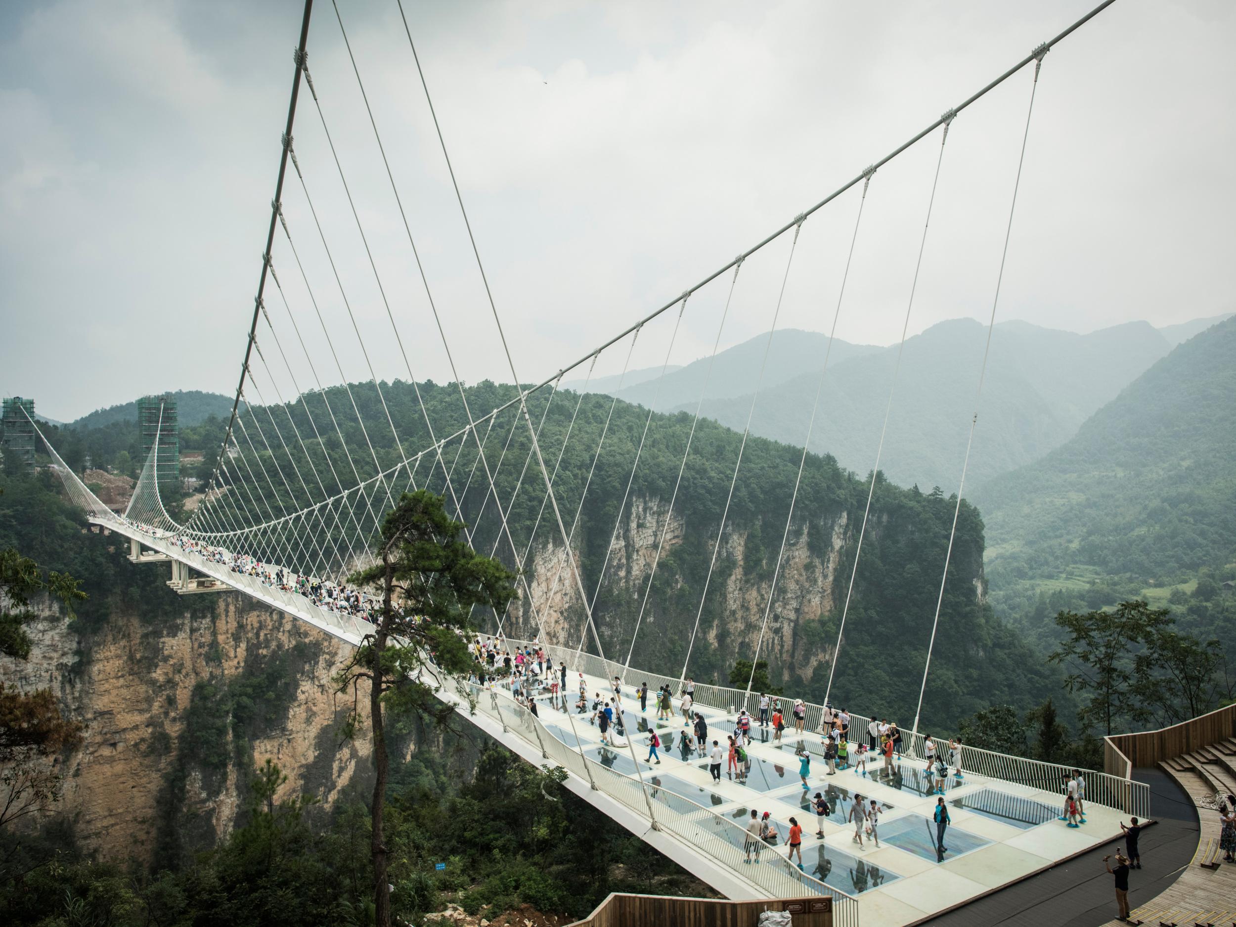 Visitors cross the world's highest and longest glass-bottomed bridge