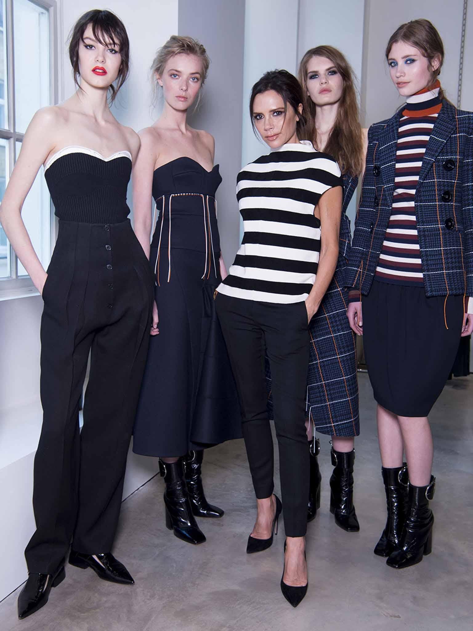 Victoria Beckham stands with models showing each of the four city looks