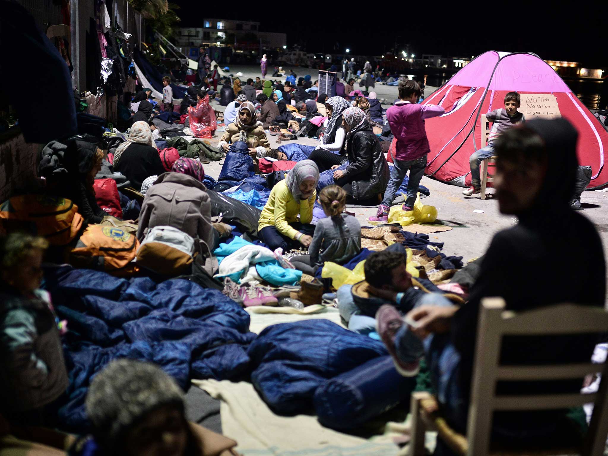 Refugees prepare to sleep at the port