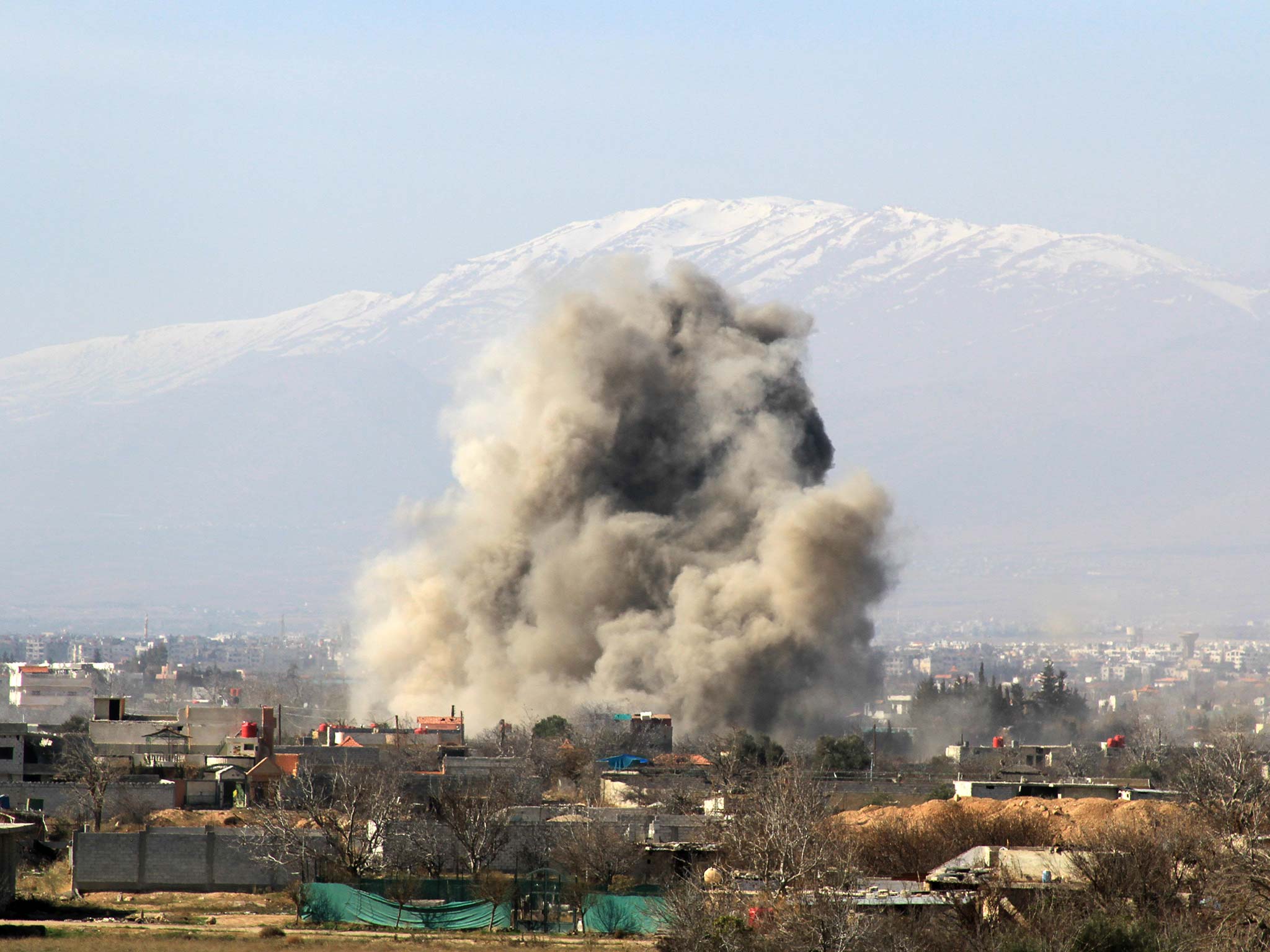 An alleged Syrian military barrel bomb explodes over Daraya in 2014