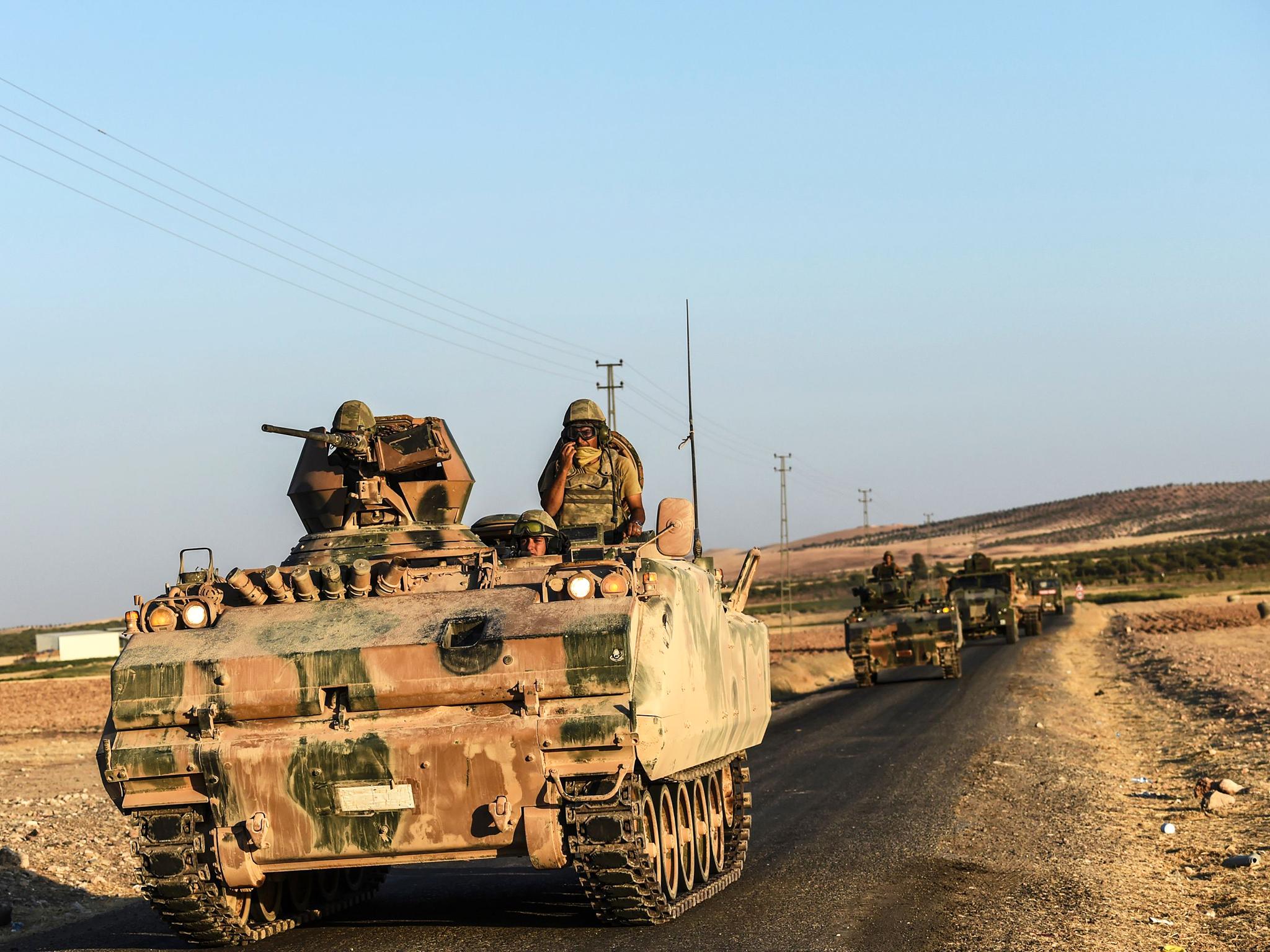 Turkish soldiers stand in a Turkish army tank driving back to Turkey from the Syrian-Turkish border town of Jarabulus on September 2, 2016 in the Turkish-Syrian border town of Karkamis