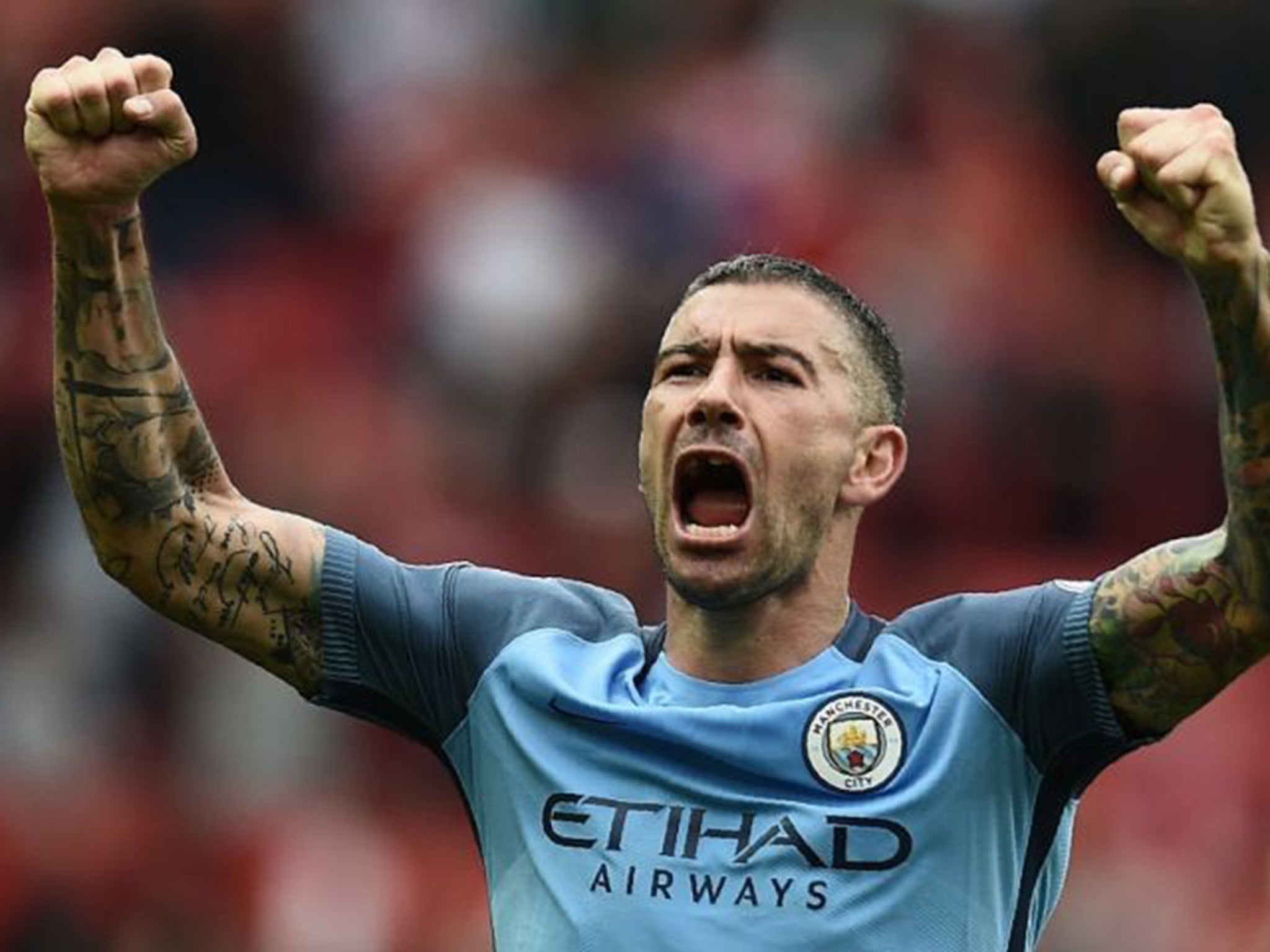 Kolarov, missing a front tooth, celebrates City's victory