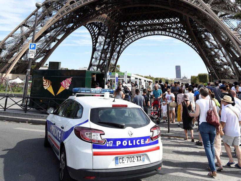 Police officers patrol around the Eiffel tower in Paris