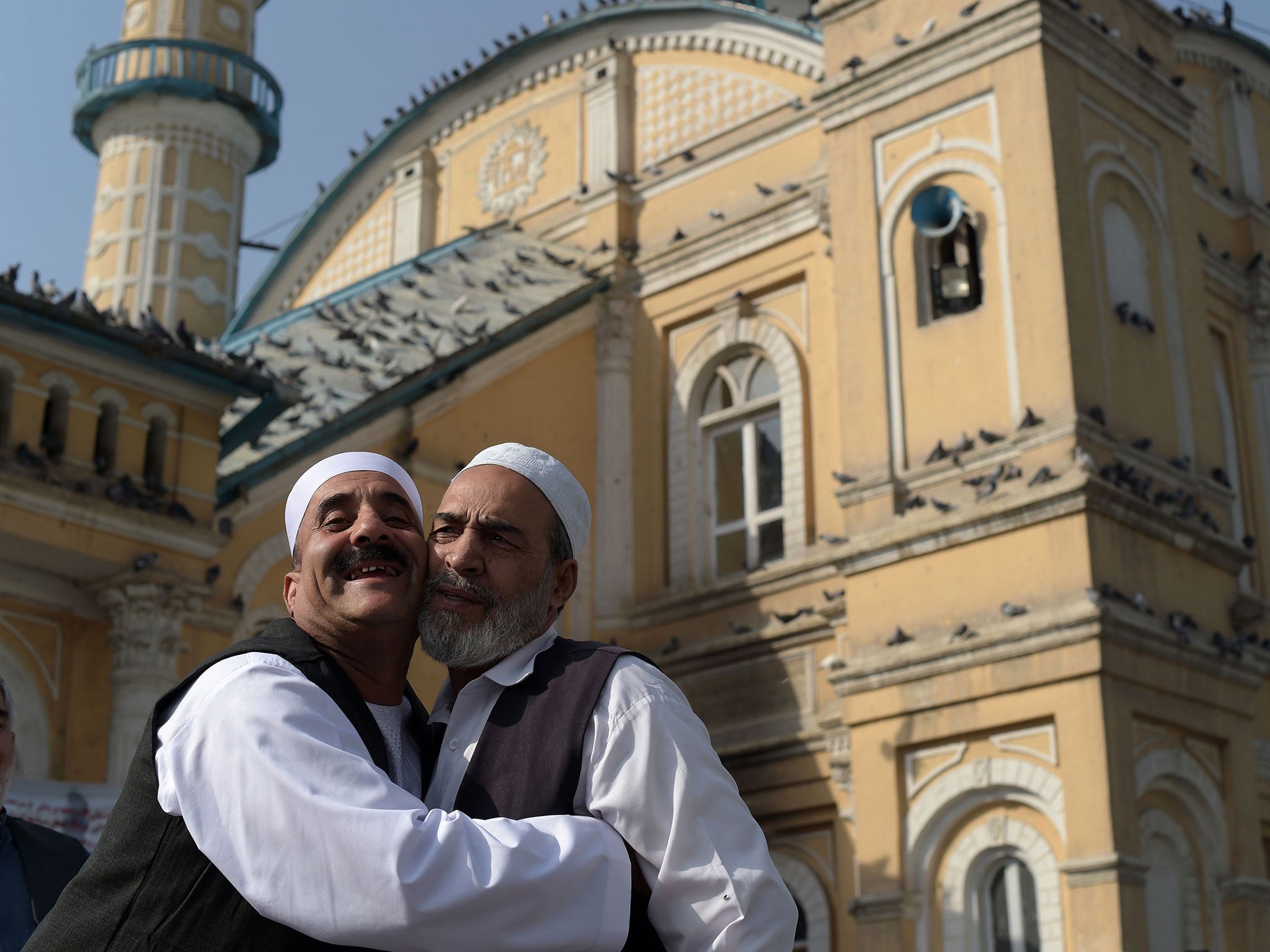 Afghan devotees greet each other after offering Eid-al-Adha prayers at the Shah-e Do Shamshira mosque in Kabul on September 12, 2016