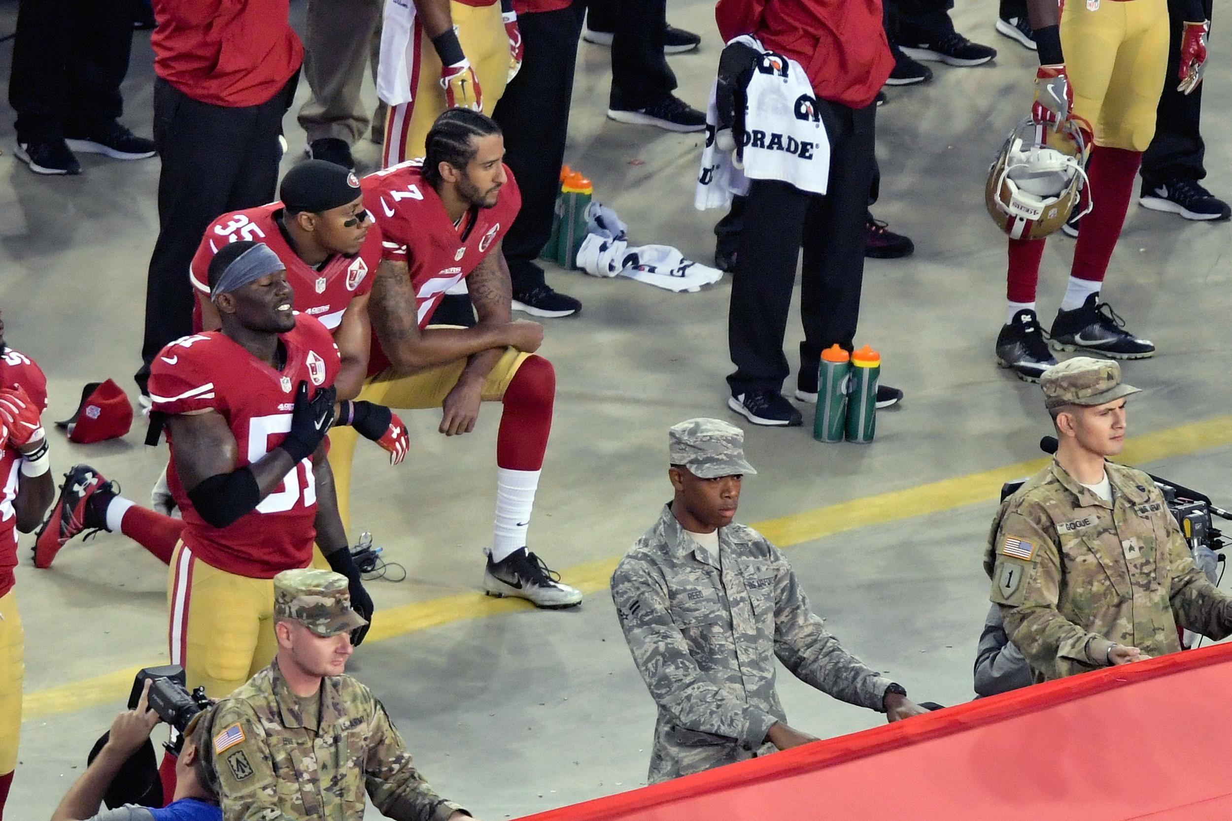 San Francisco 49ers quarterback Colin Kaepernick and teammate Eric Reid (35) kneel during the playing of the national anthem