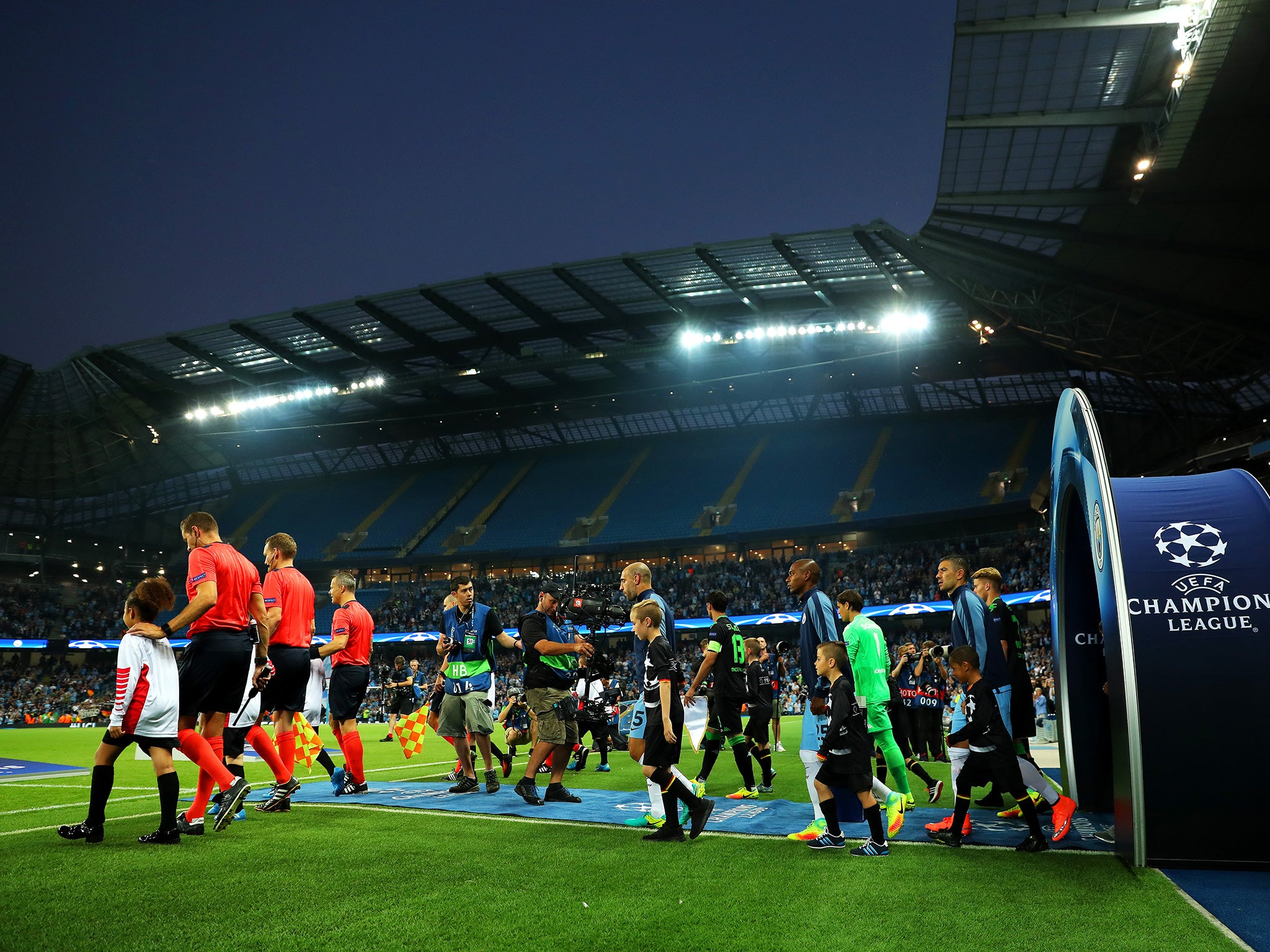 The players walk out in front of the Etihad's partially-closed South Stand