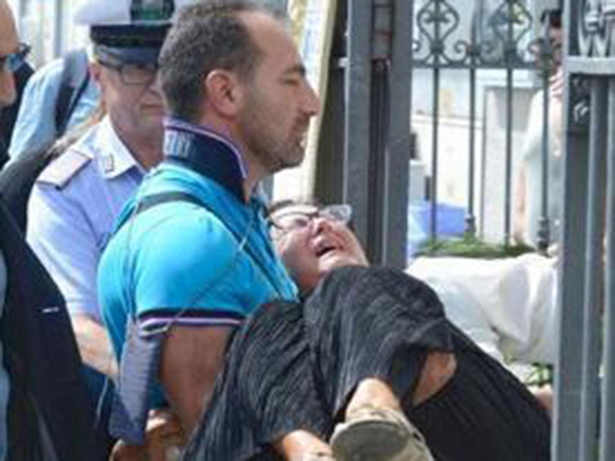 A man carries Teresa Giglio, the mother of Tiziana Cantone, into her daughter's funeral