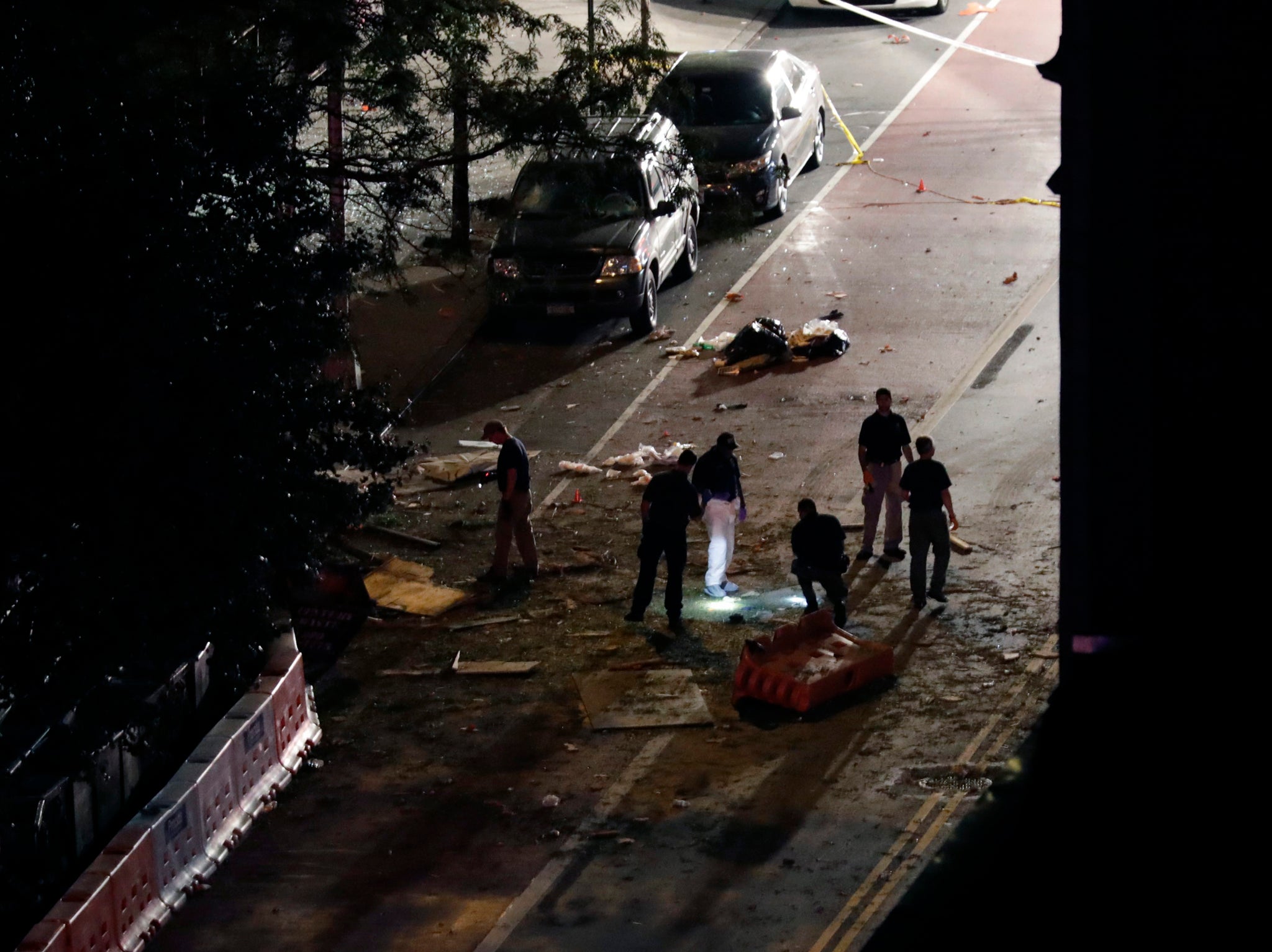 Police investigators look through the debris on the street in front of St. Vincent de Paul church where the explosion occurred