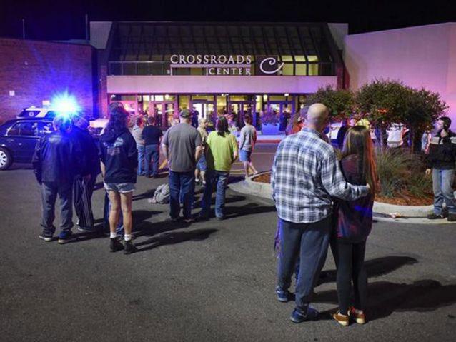 People stand near the entrance on the north side of Crossroads Center mall between Macy's and Target as officials investigate a reported multiple stabbing incident, Saturday, 17 September, 2016, in St Cloud, Minnesota