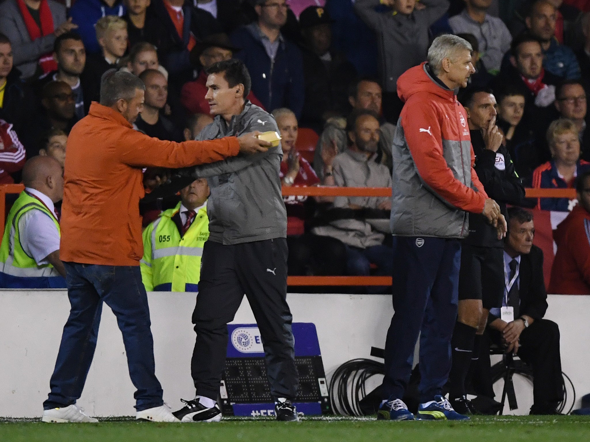 A spectator offers his pie to Wenger, the Arsenal manager