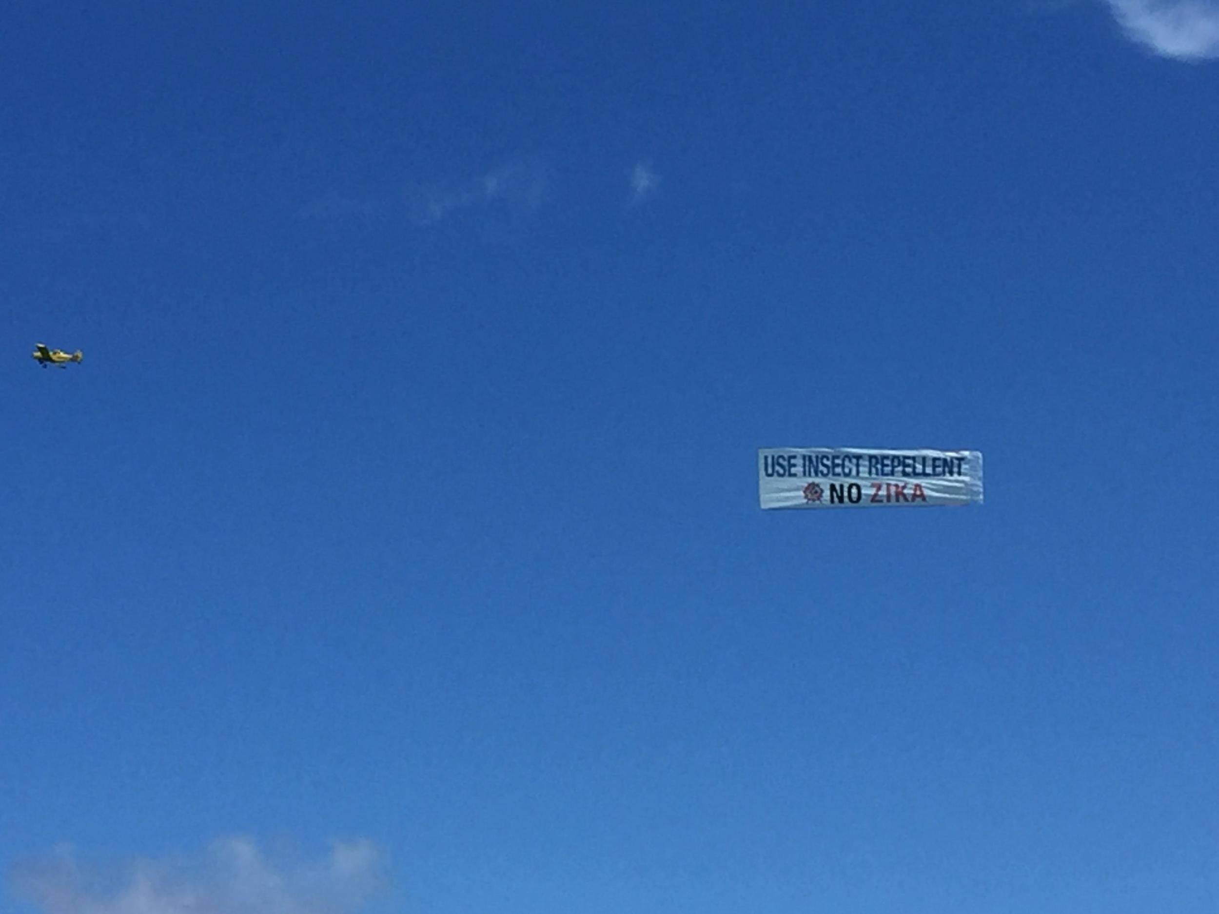 A plane trails a Zika public health warning down the beach this week