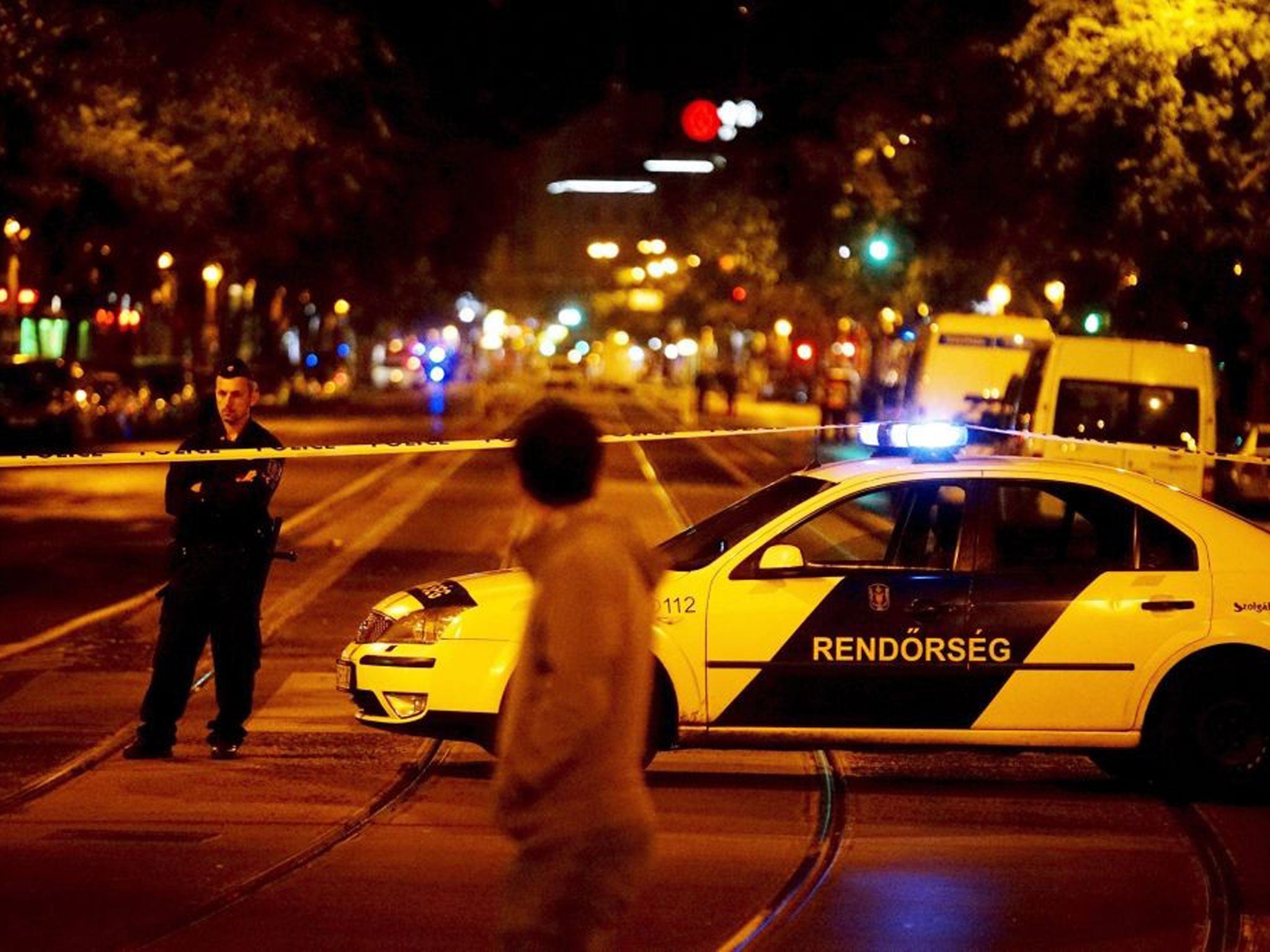 A passer-by looks at an area cordoned off by police near the scene in central Budapest