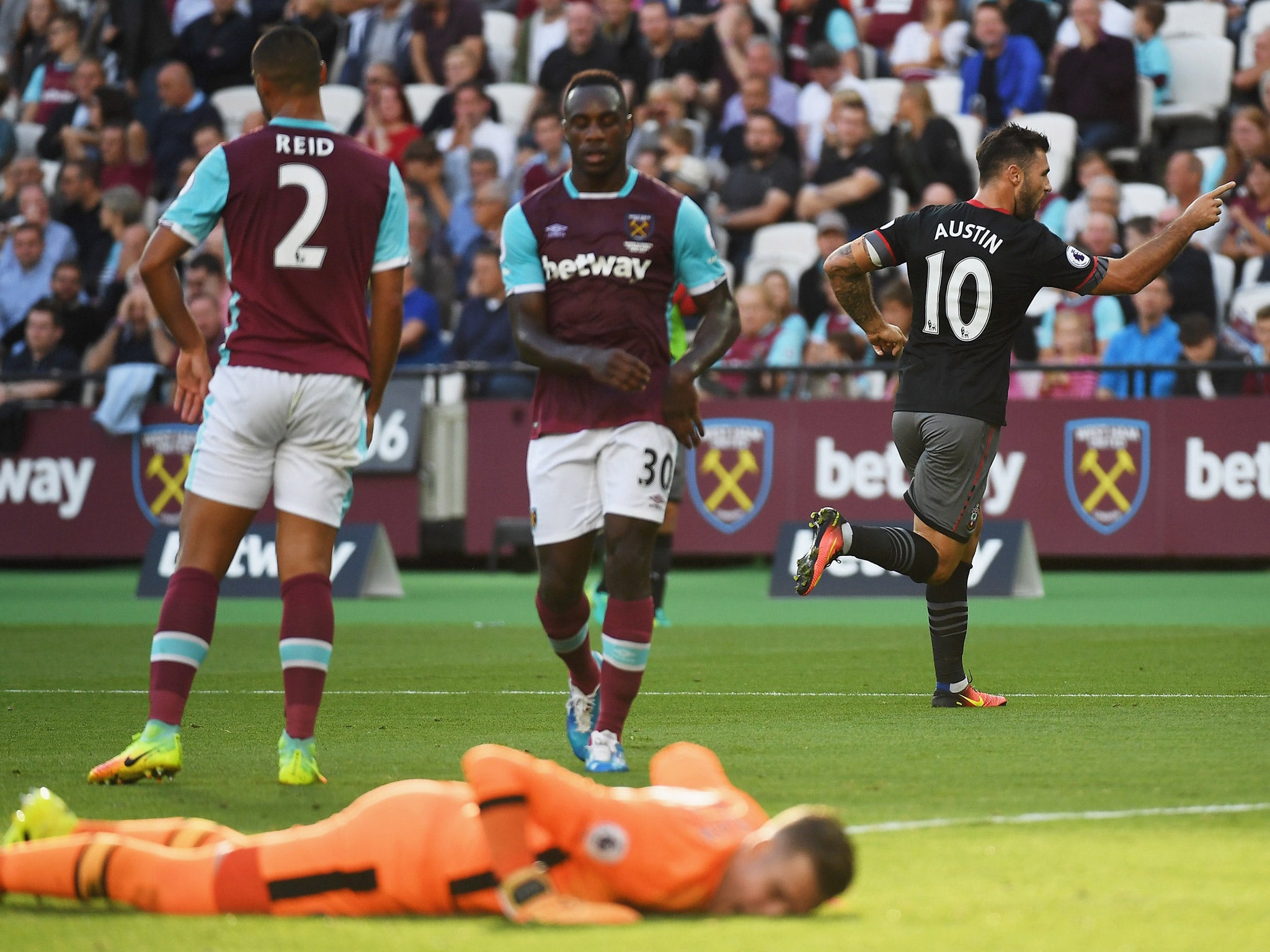 Charlie Austin peels away to celebrate as West Ham players look disconsolate