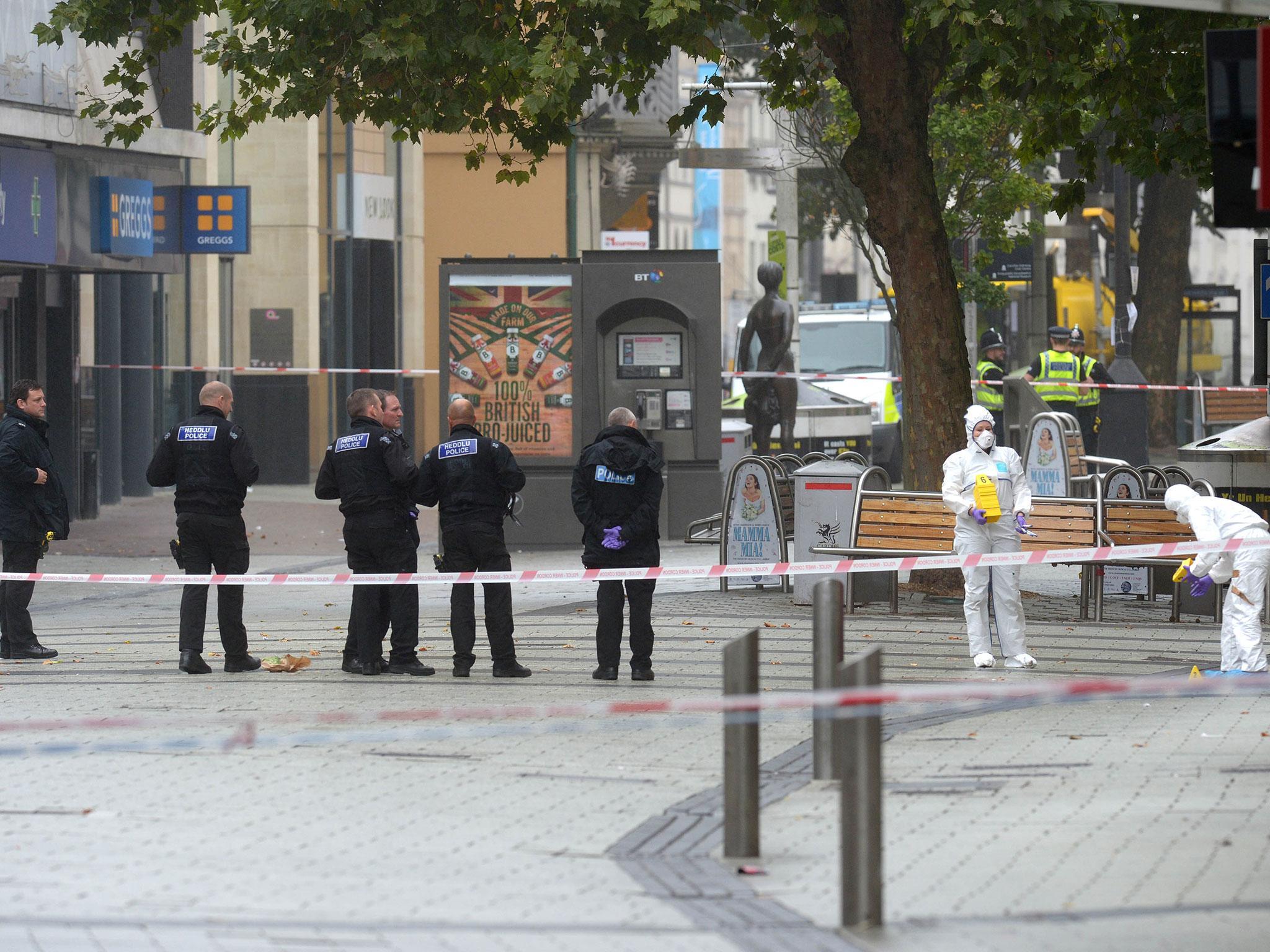 Police and forensics officers at the scene in Queen Street, near Cardiff Castle after the bodies of a man and a woman were found in Cardiff city centre