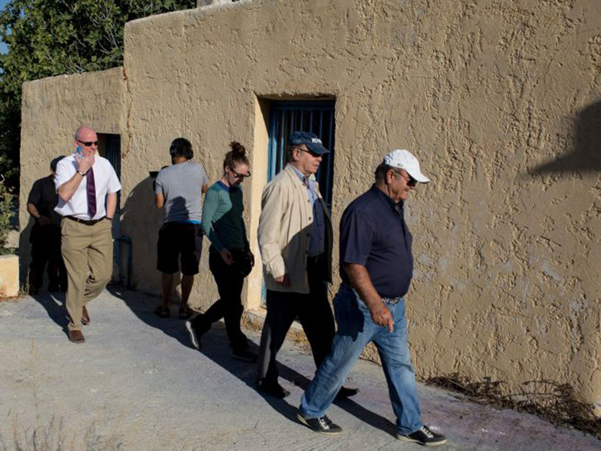 Greek engineers meet detectives outside the farmhouse in Kos