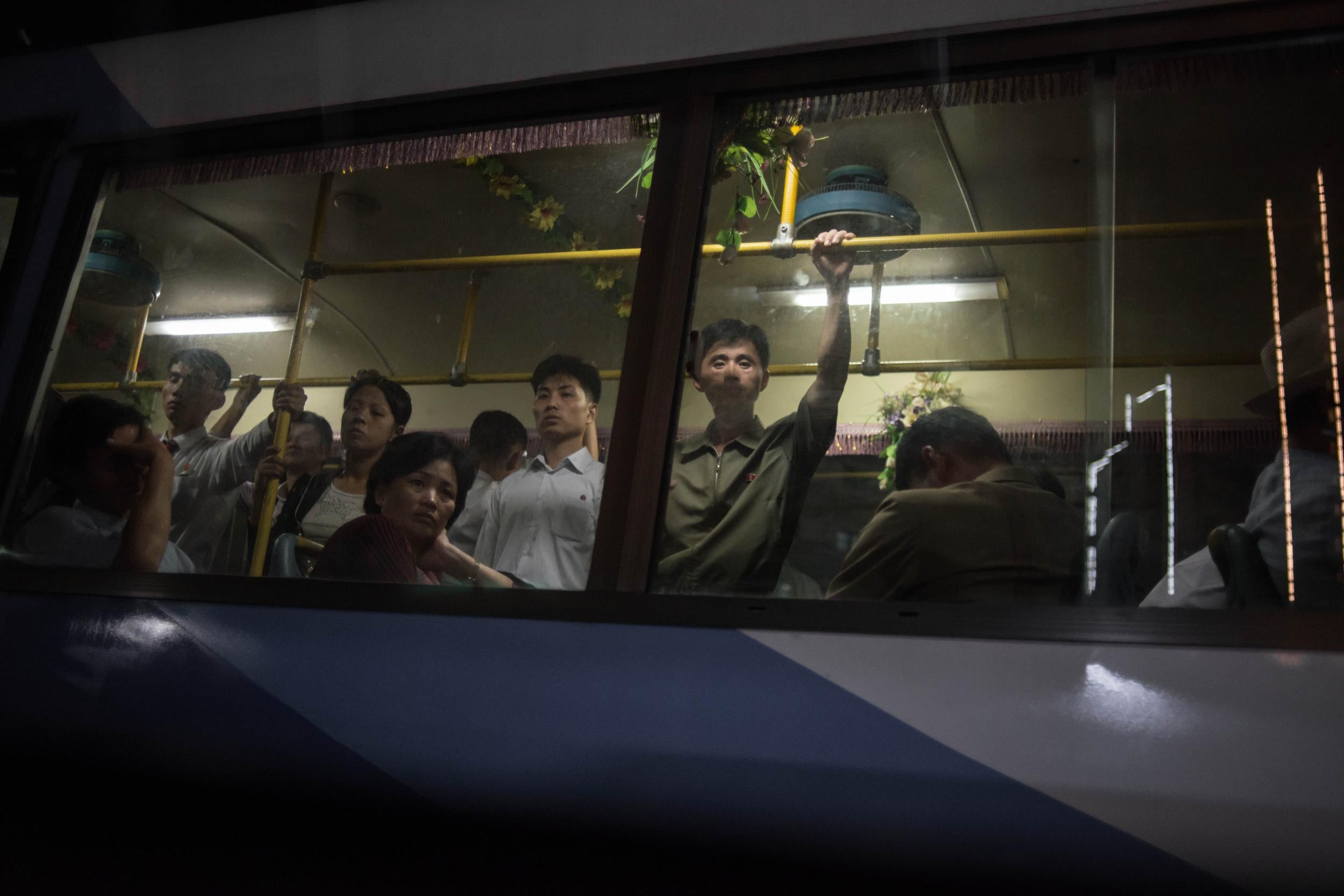 Commuters ride a bus during the evening rush hour in North Korea's capital city, Pyongyang