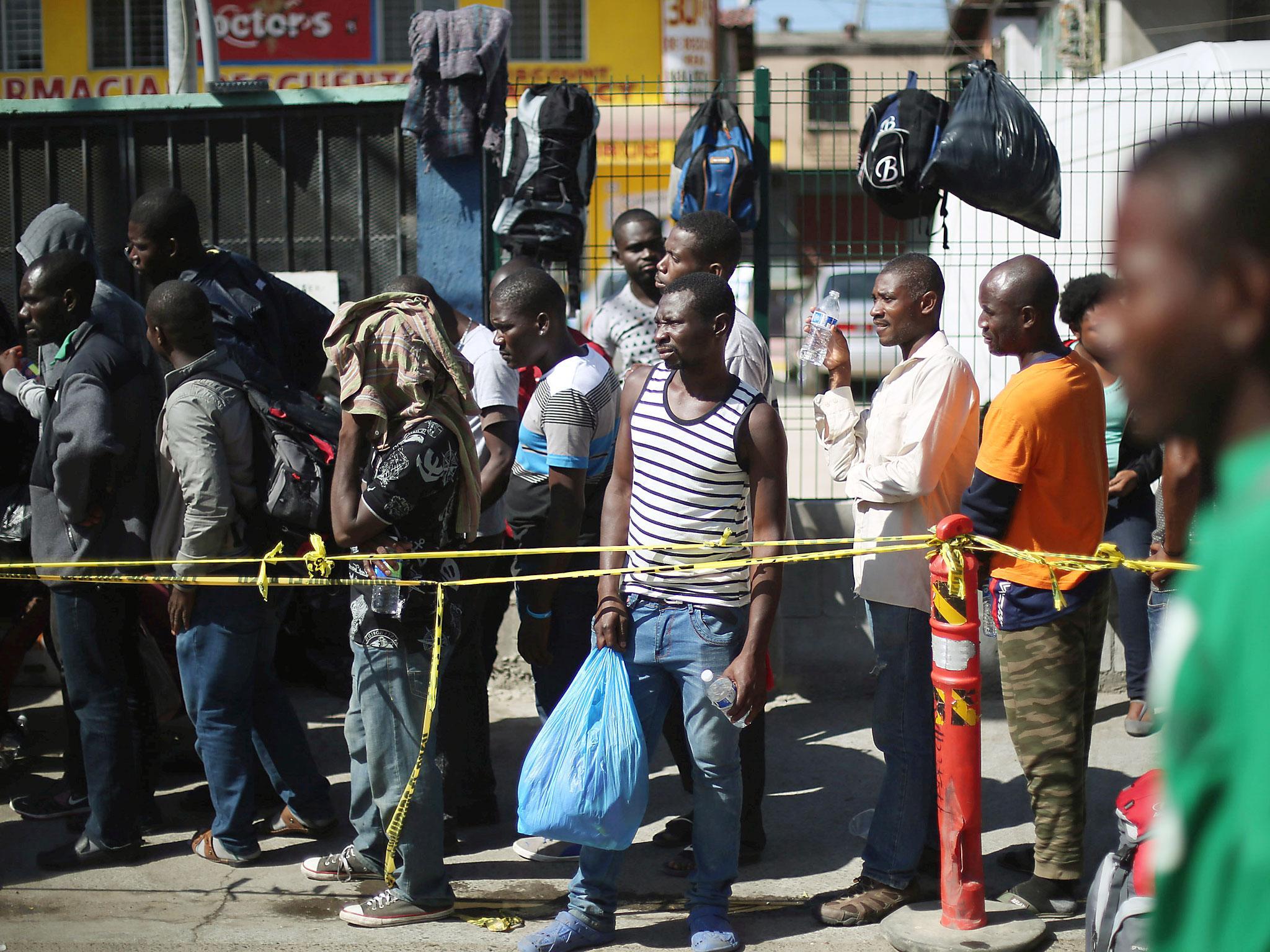 Haitian migrants line up outside Padre Chava shelter