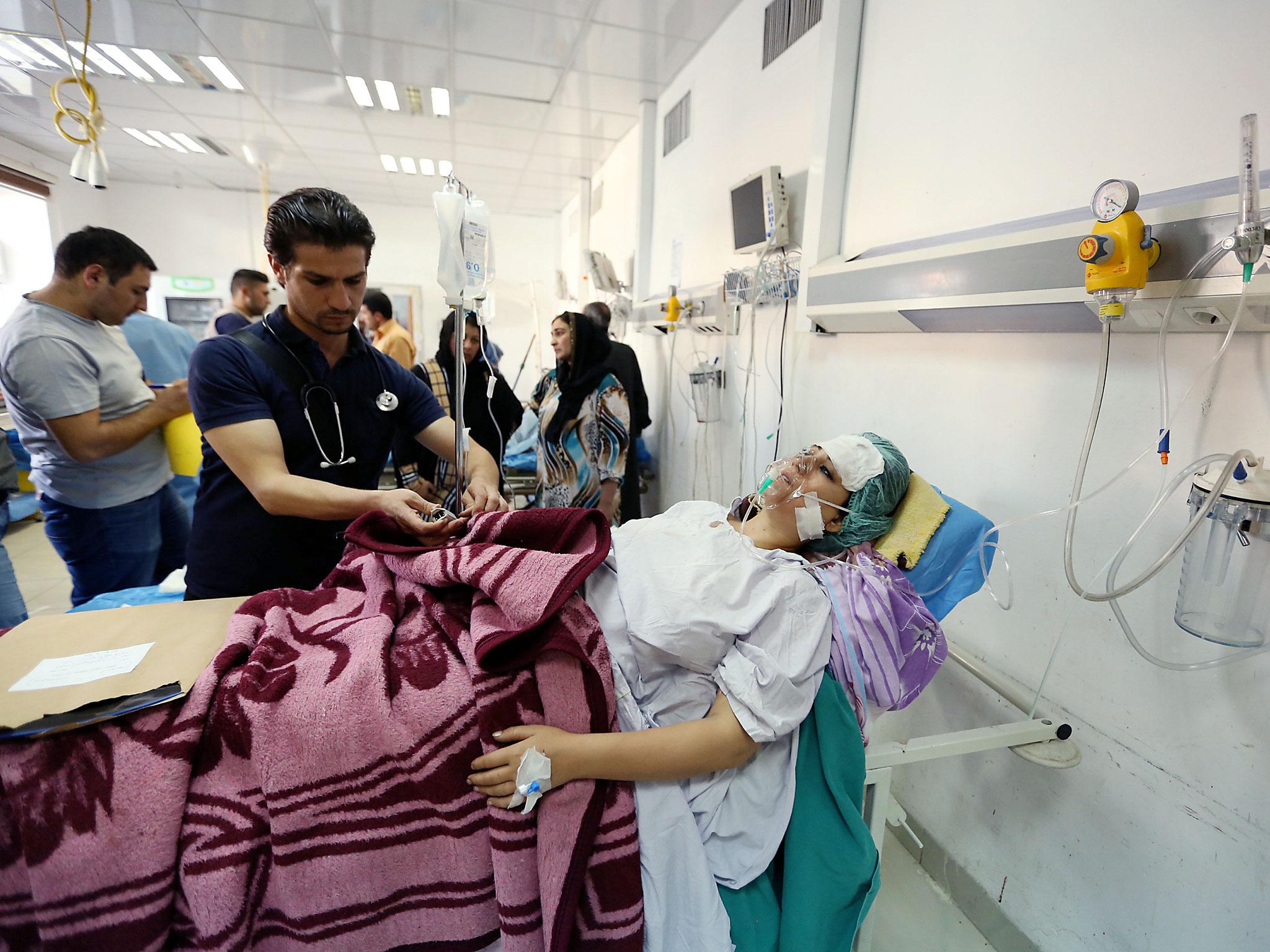 A woman, who was wounded in a bombing at a Kurdish wedding in the northeast Syrian city of Hasaka, lies in a hospital in Dohuk province, Iraq