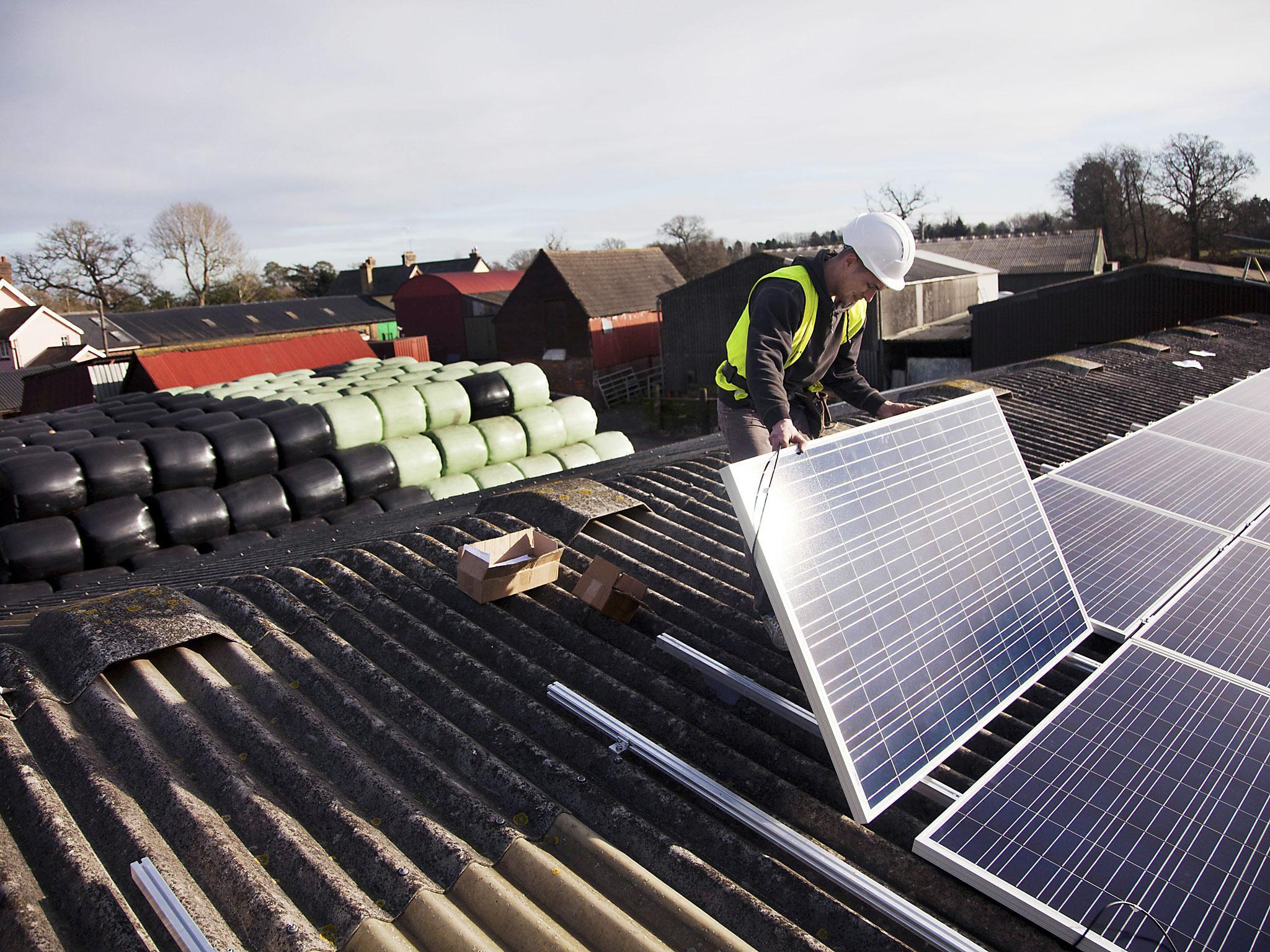 Jake Beautyman installs solar panels on a barn roof on Grange farm, near Balcombe. The installation is part of an initiative by local residents in Balcombe to encourage more people to use renewable energy rather than energy based on carbon such as fracking. The initaitive is called Repowerbalcombe and is supported by the charity 10:10