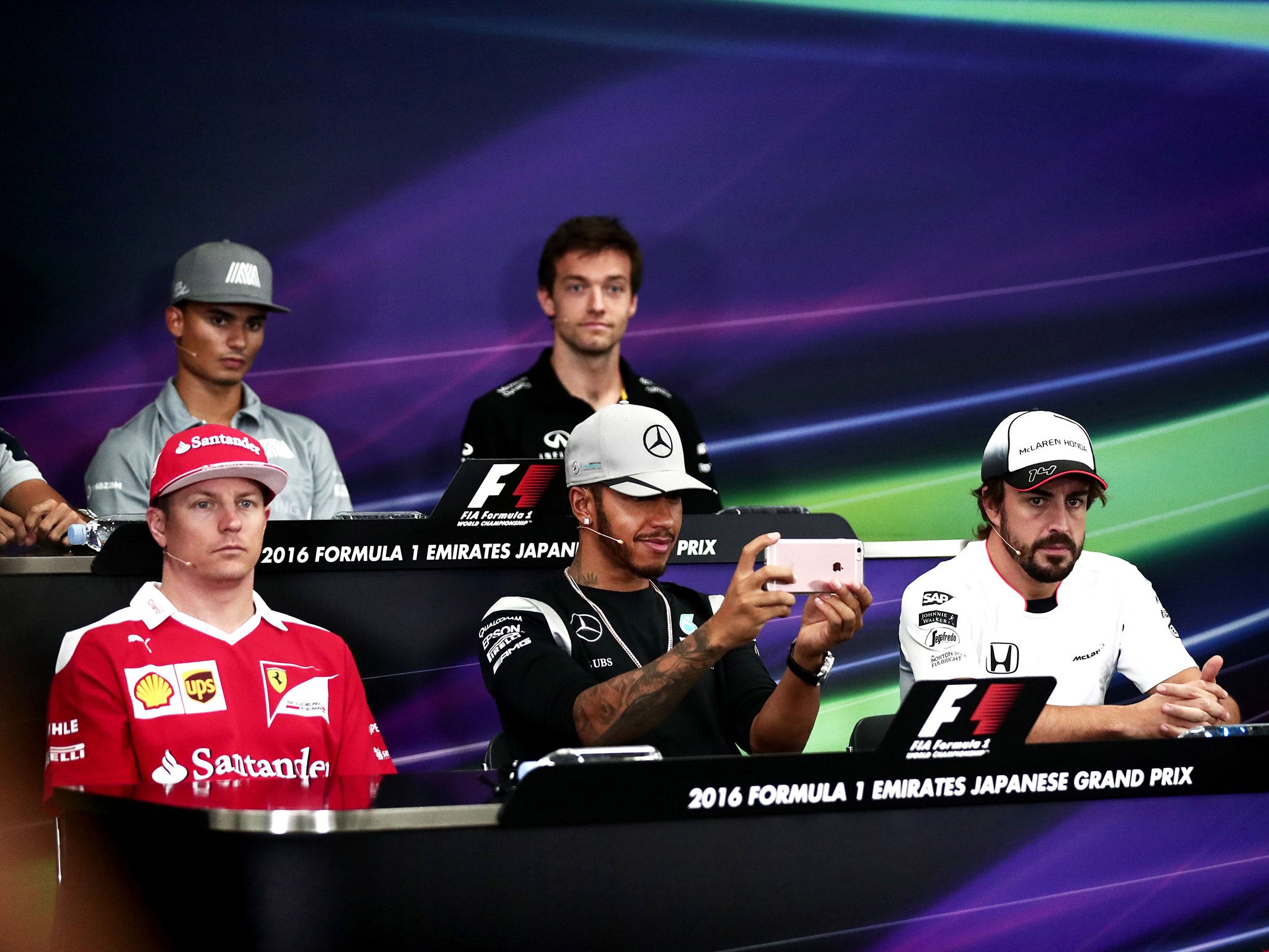 Hamilton occupied himself during the press conference by playing with his mobile phone