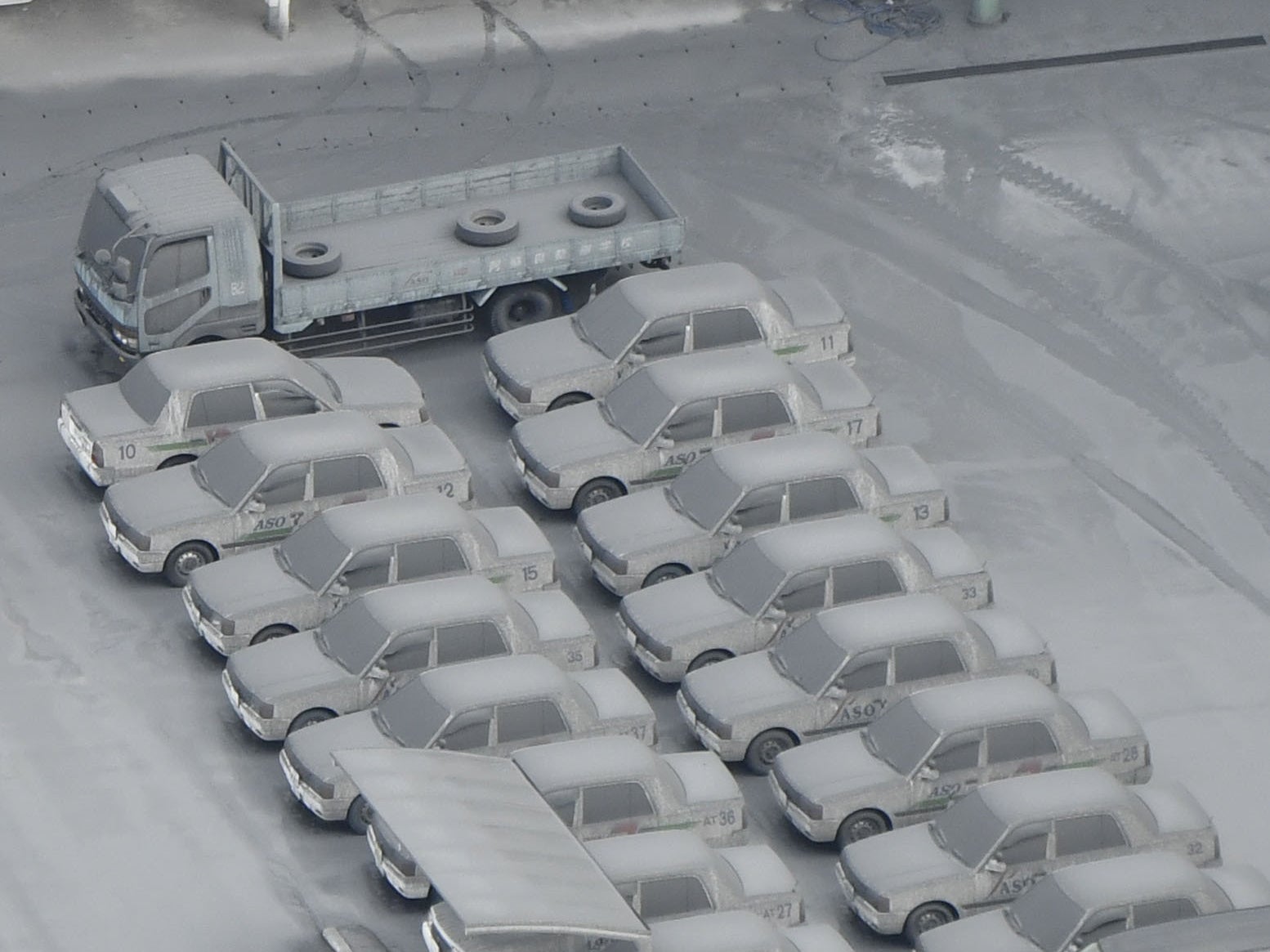 Cars are covered with volcanic ashes from Mount Aso in Aso