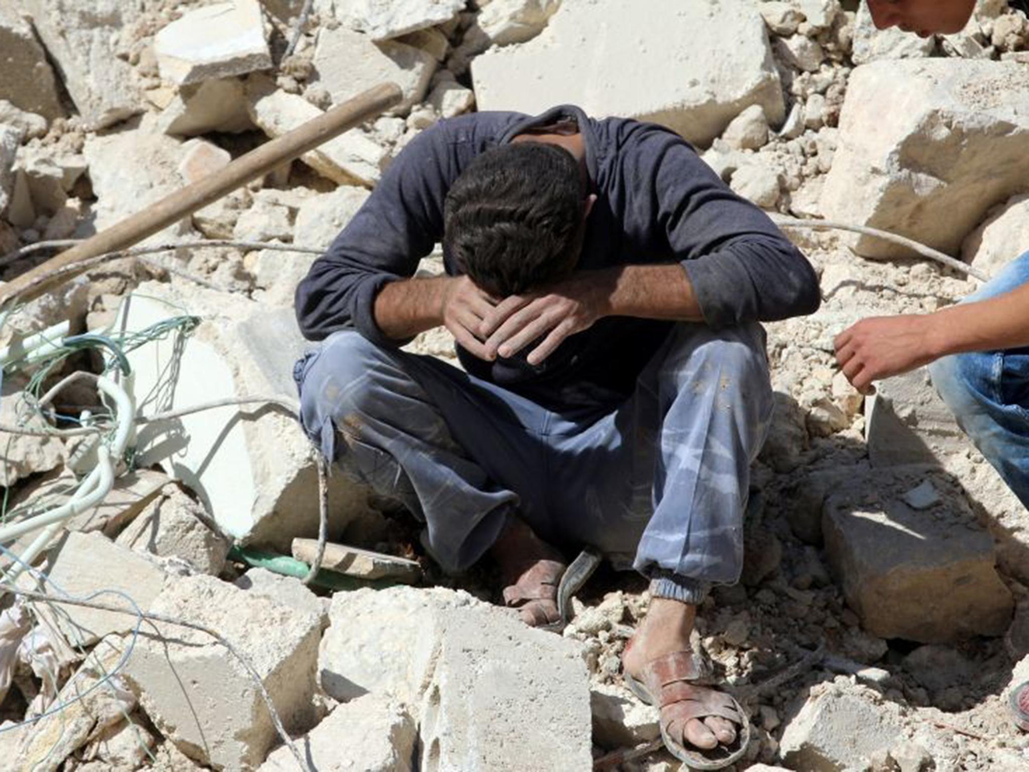 A man grieves for his relatives after an air strike in Aleppo, a city split between government in the west and rebels in the east since 2012