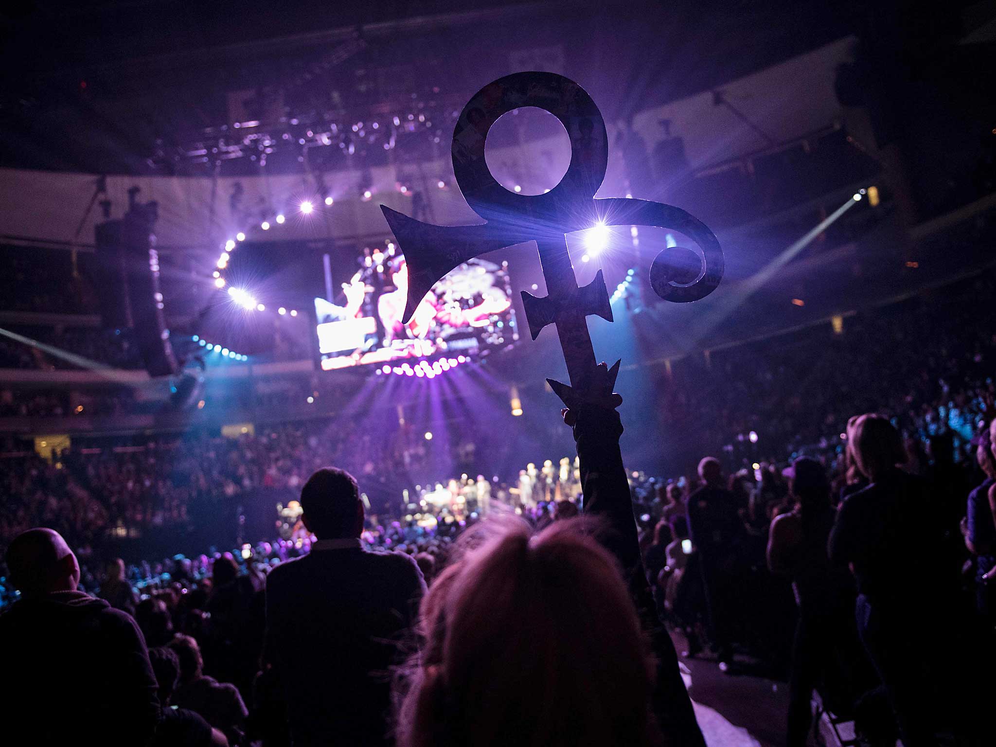 A woman holds up a Prince symbol during an Prince Official Tribute concert in St Paul, Minnesota