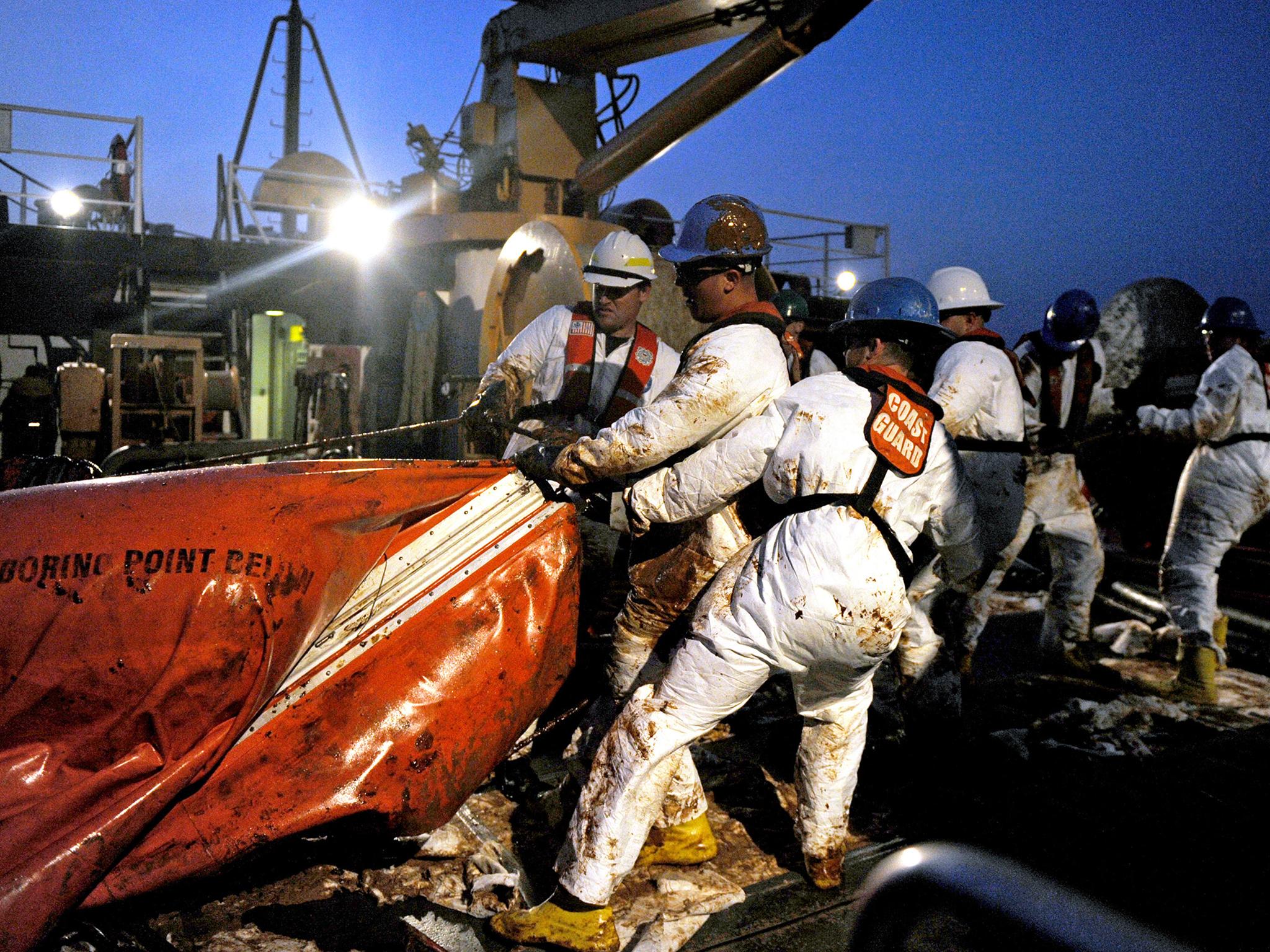 US Department of Defence crew members remove an oil covered boom from the ocean in the Gulf of Mexico in May 2010 (Getty)