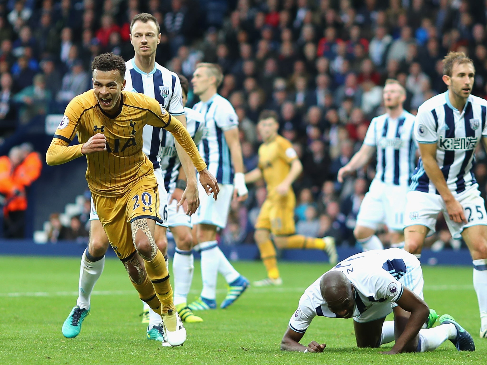 Alli celebrates scoring late on to salvage a draw