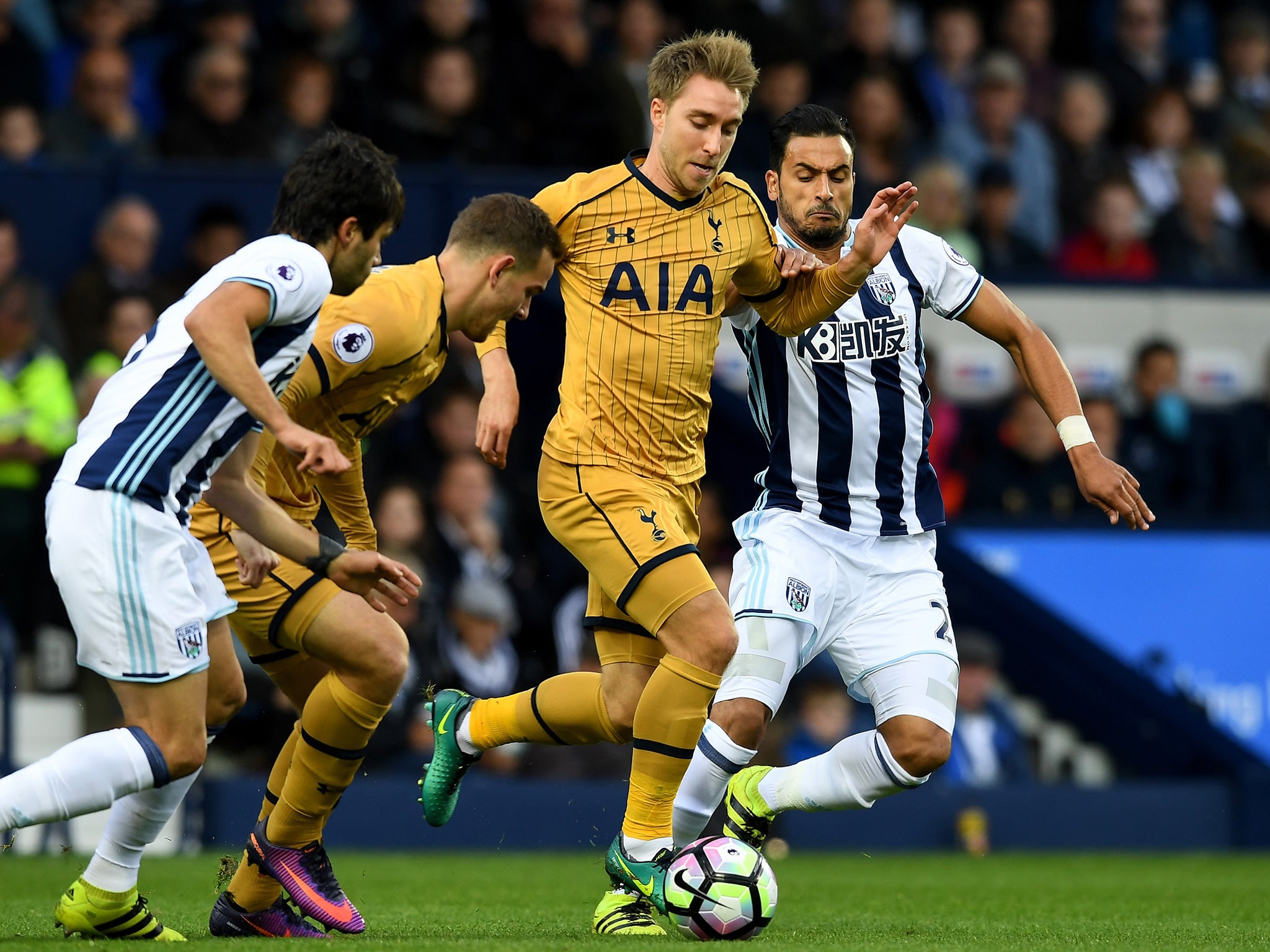 Eriksen carries the ball forward under pressure from Chadli