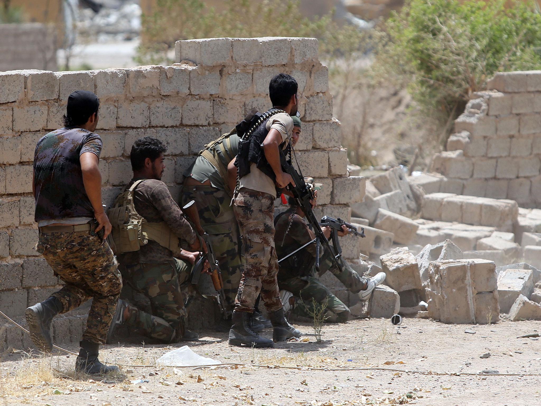 Armed Iraqi Shia fighters from the Popular Mobilisation Units, supporting Iraqi government forces, guard a position during clashes with Isis militants on 15 July, 2015 in the town of Saqlawiya on the outskirts of Fallujah, 50km west of Baghdad