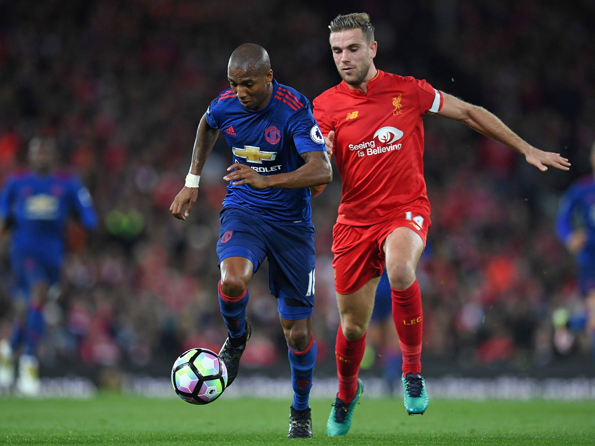 Manchester United's Ashley Young takes the ball out of defence despite Jordan Henderson's efforts